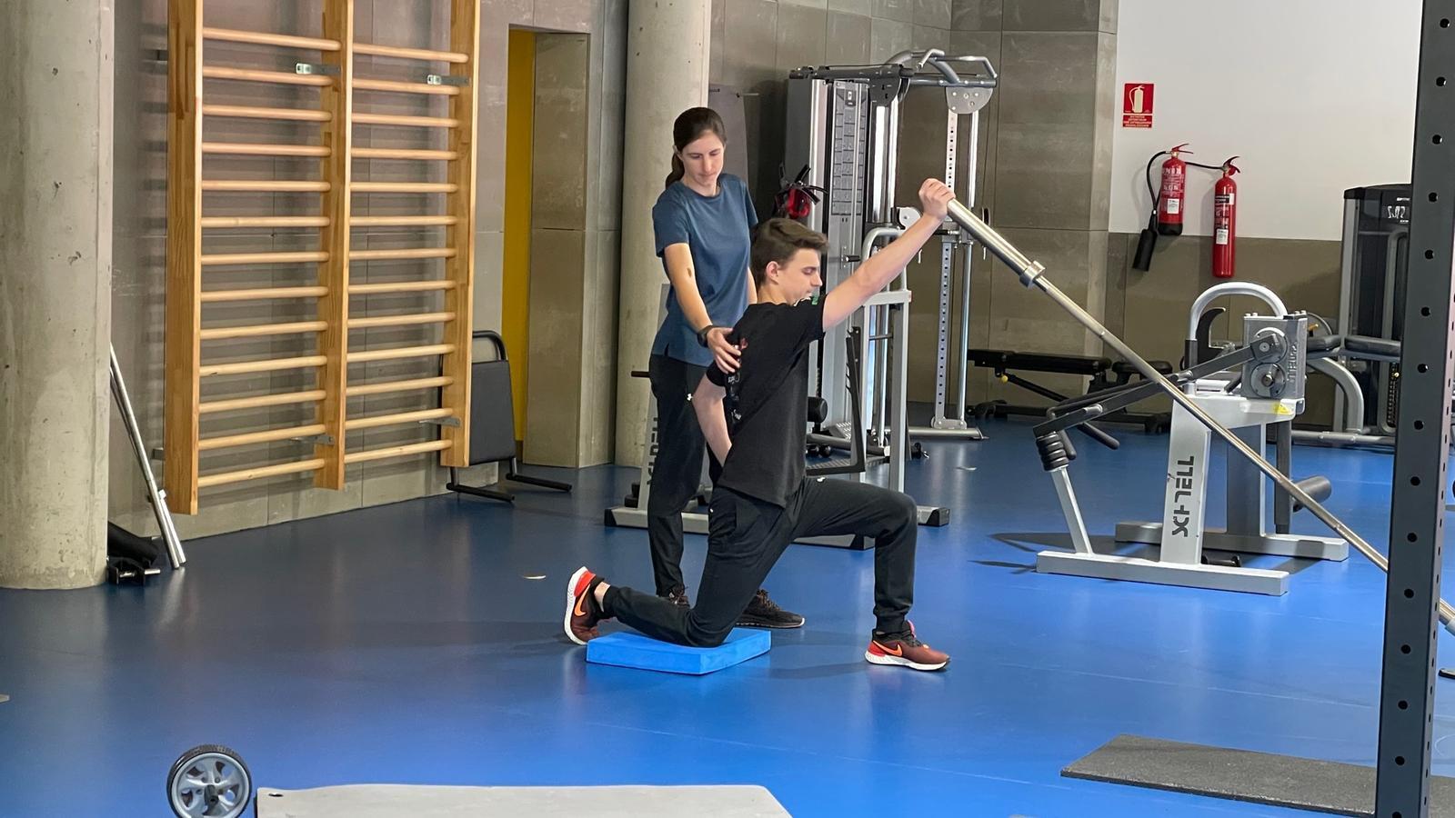 Torres ajuda un dels esportistes del CTEO a realitzar un exercici.