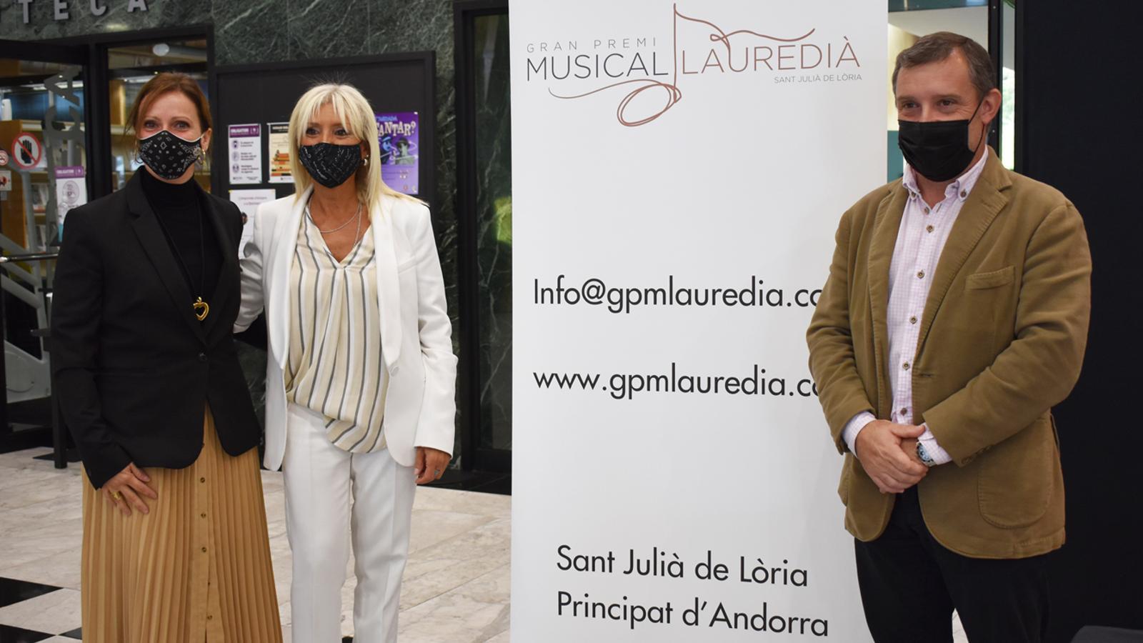 Els cònsols de Sant Julià de Lòria, Josep Majoral i Mireia Codina, i la directora del Gran Premi Musical Lauredià, Roser Palomero, amb el cartell de l'esdeveniment.