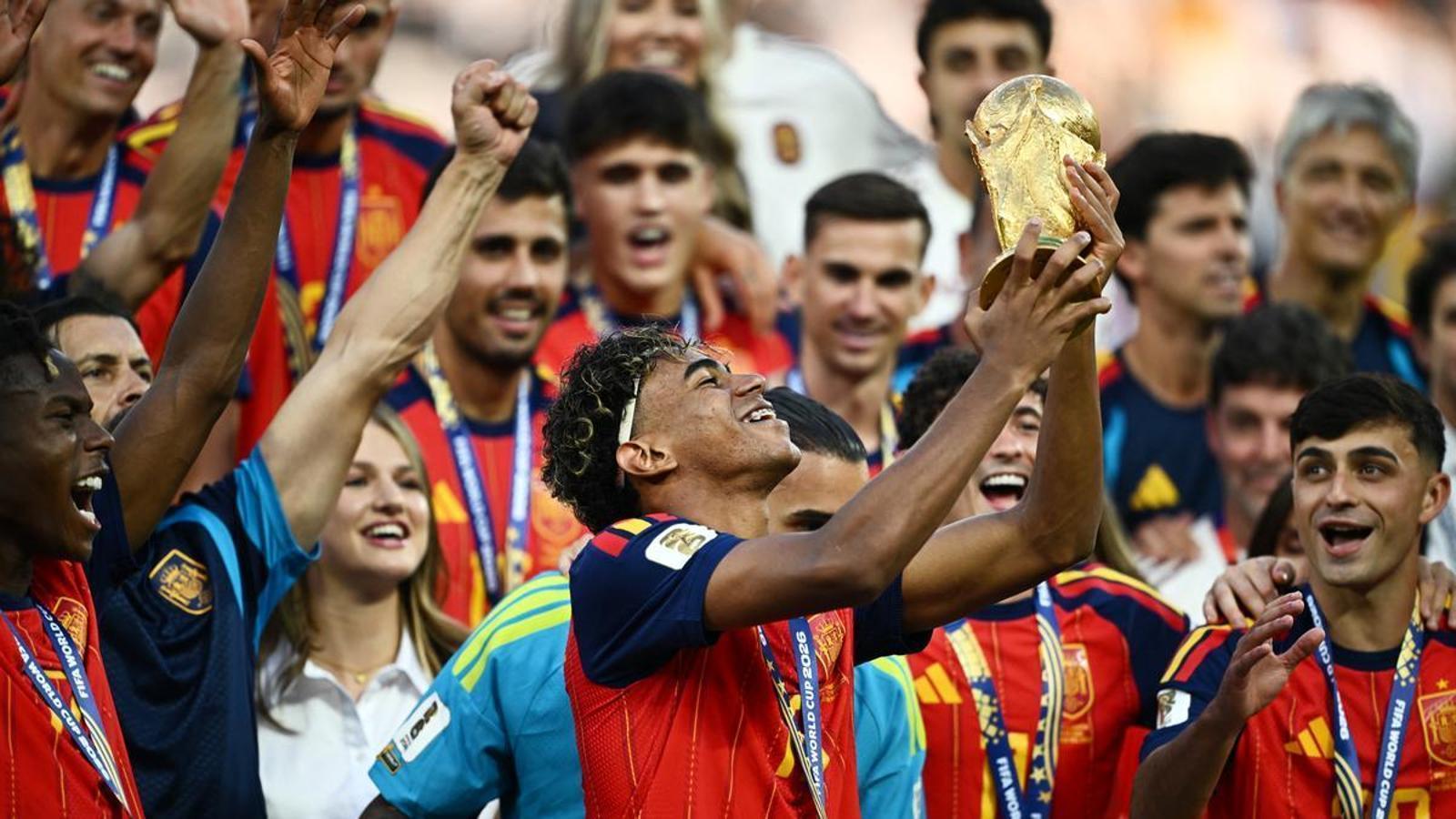 Lamine Yamal, from Spain, lifts the World Cup trophy with his teammates as they celebrate the tournament victory.