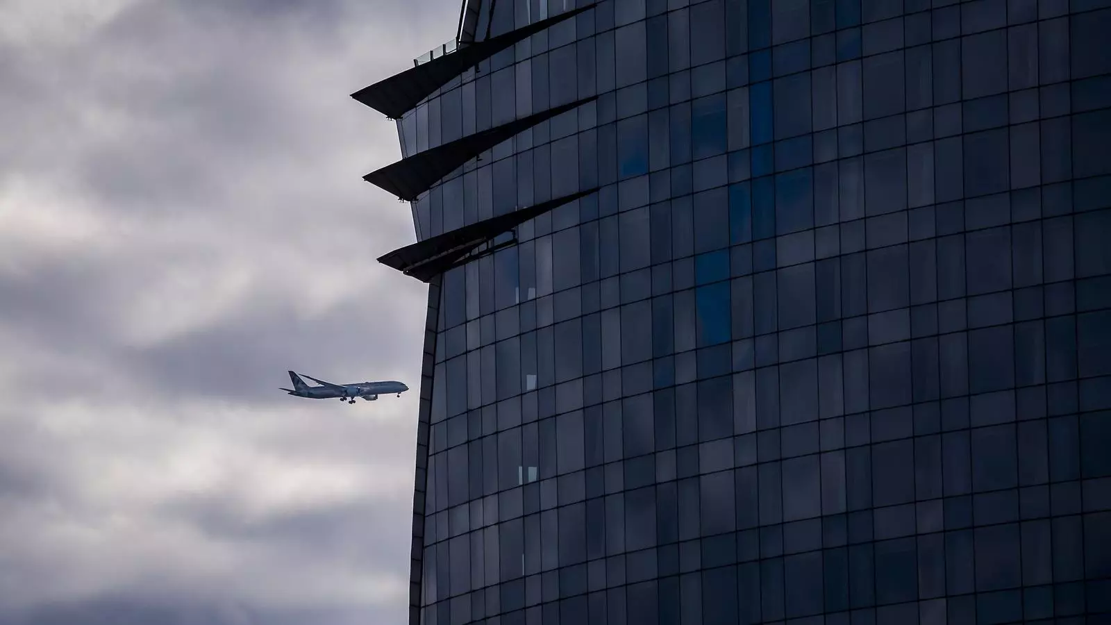 Un avió passat per darrere l'hotel Vela.