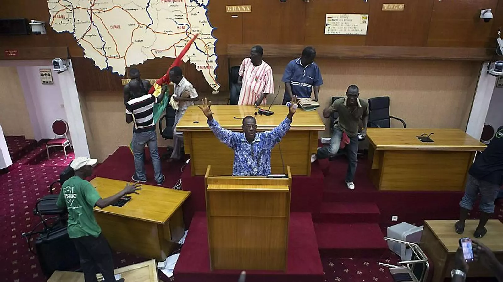 LA VEU DEL CARRER Els manifestants van aconseguir entrar a l’interior de l’edifici del Parlament, a la capital Ouagadougou, com aquest grup que es passeja lliurement per l’hemicicle. La revolta també es va traslladar fins a les instal·lacions de la televisió pública i membres del moviment ciutadà van tallar les emissions regulars.