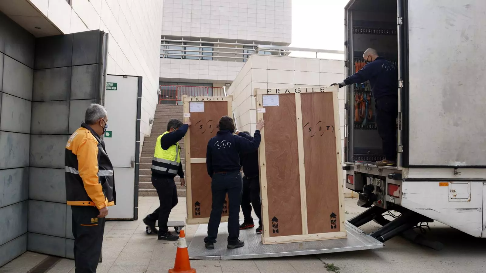 Operaris carregant algunes de les peces d'art sacre al camió per al trasllat