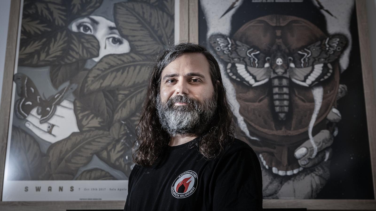 Xavi Forné, in front of some of the posters he has designed in recent years, specifically those he made for Metallica and Swans.