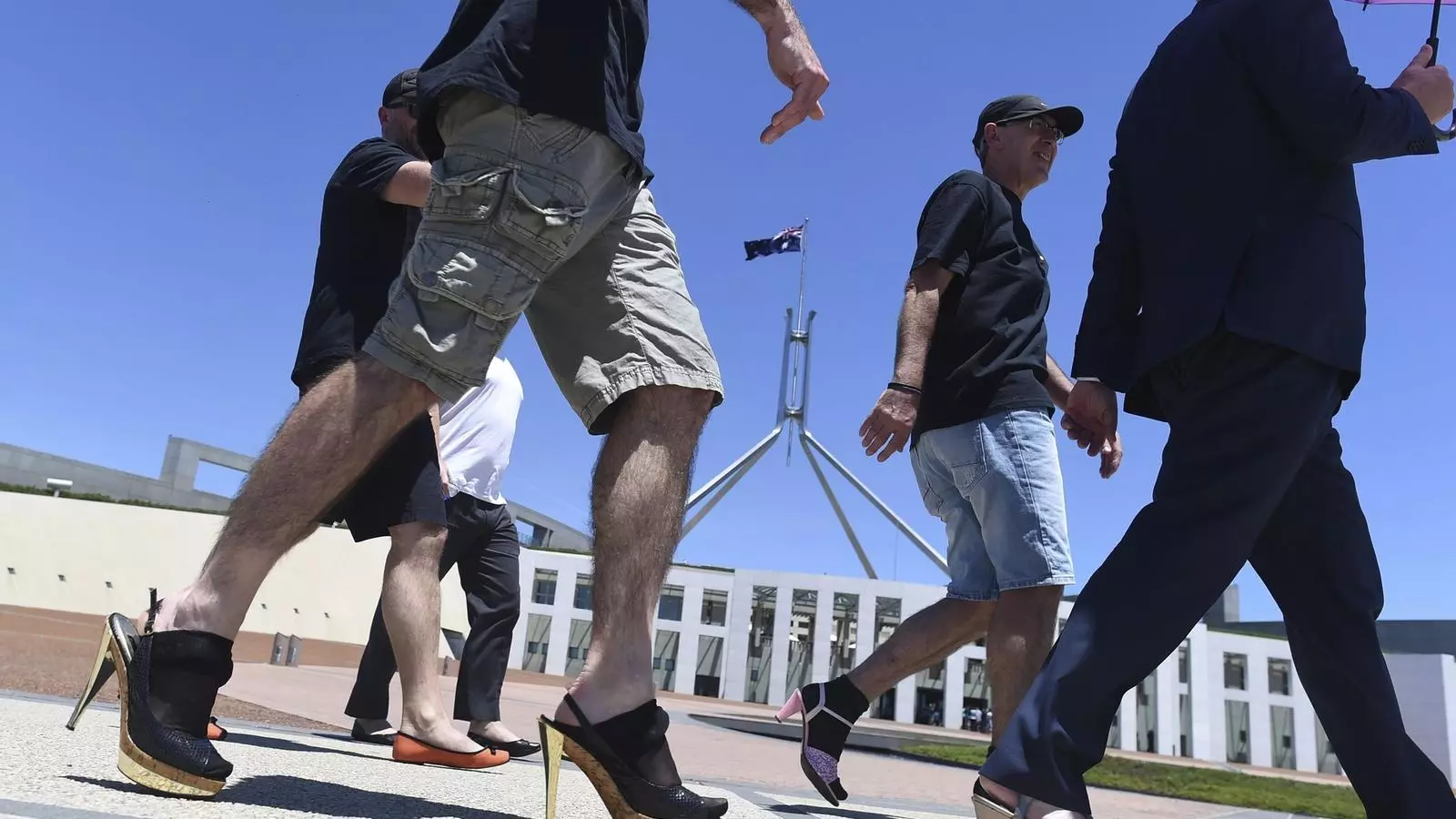 Funcionaris del departament d'Afers Exteriors d'Austràlia caminen sobre talons davant les portes del Parlament / EFE