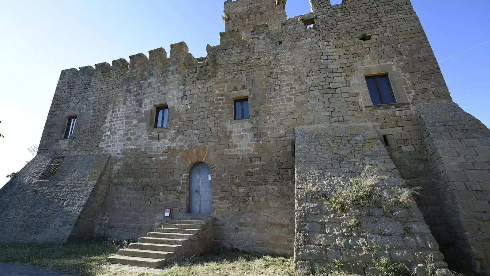 El castell té contraforts a les cantonades i una porta elevada per dificultar-hi l’accés.