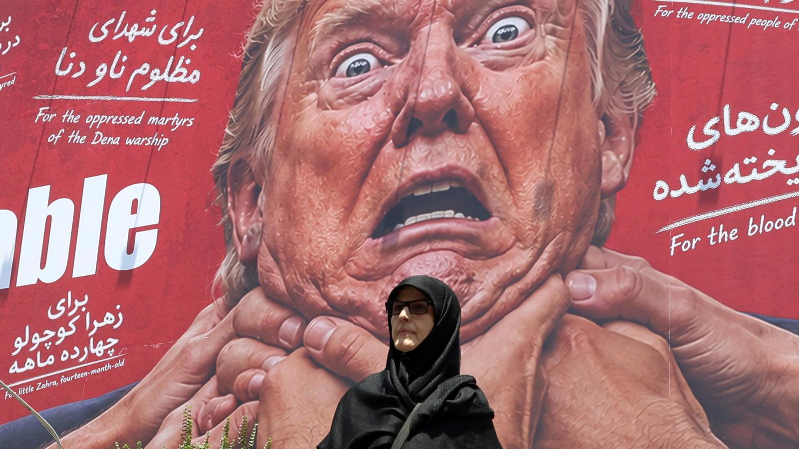 Una mujer pasa delante de una valla publicitaria antinorteamericana y anti-Trump en una calle de Teherán, en Irán.