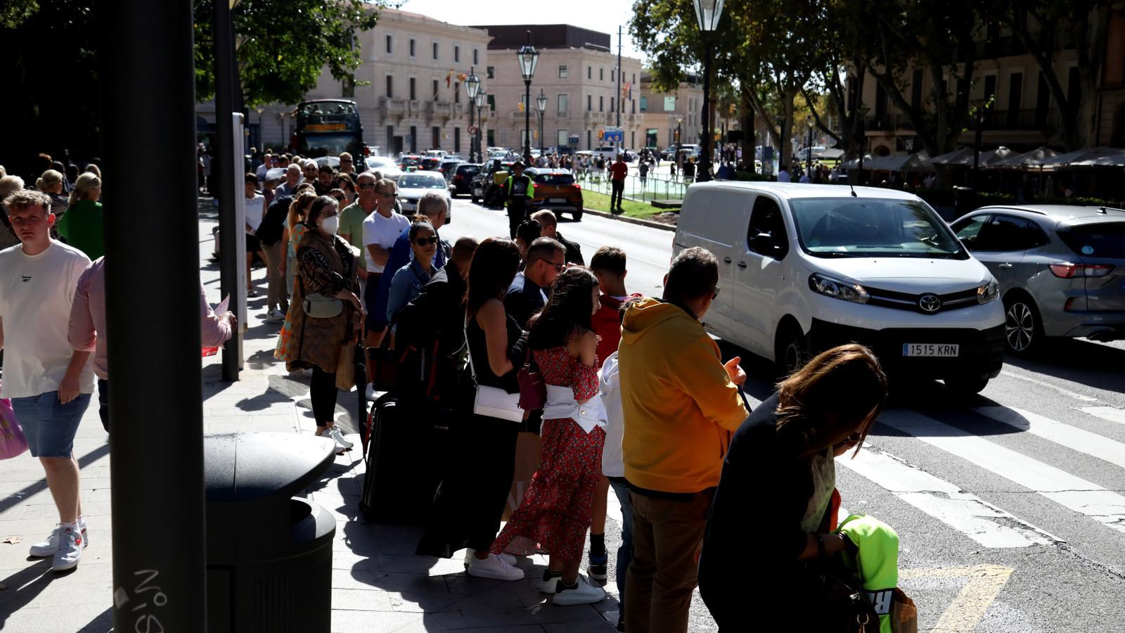 Turistes esperant a l'aturada de l'autobús, a Palma