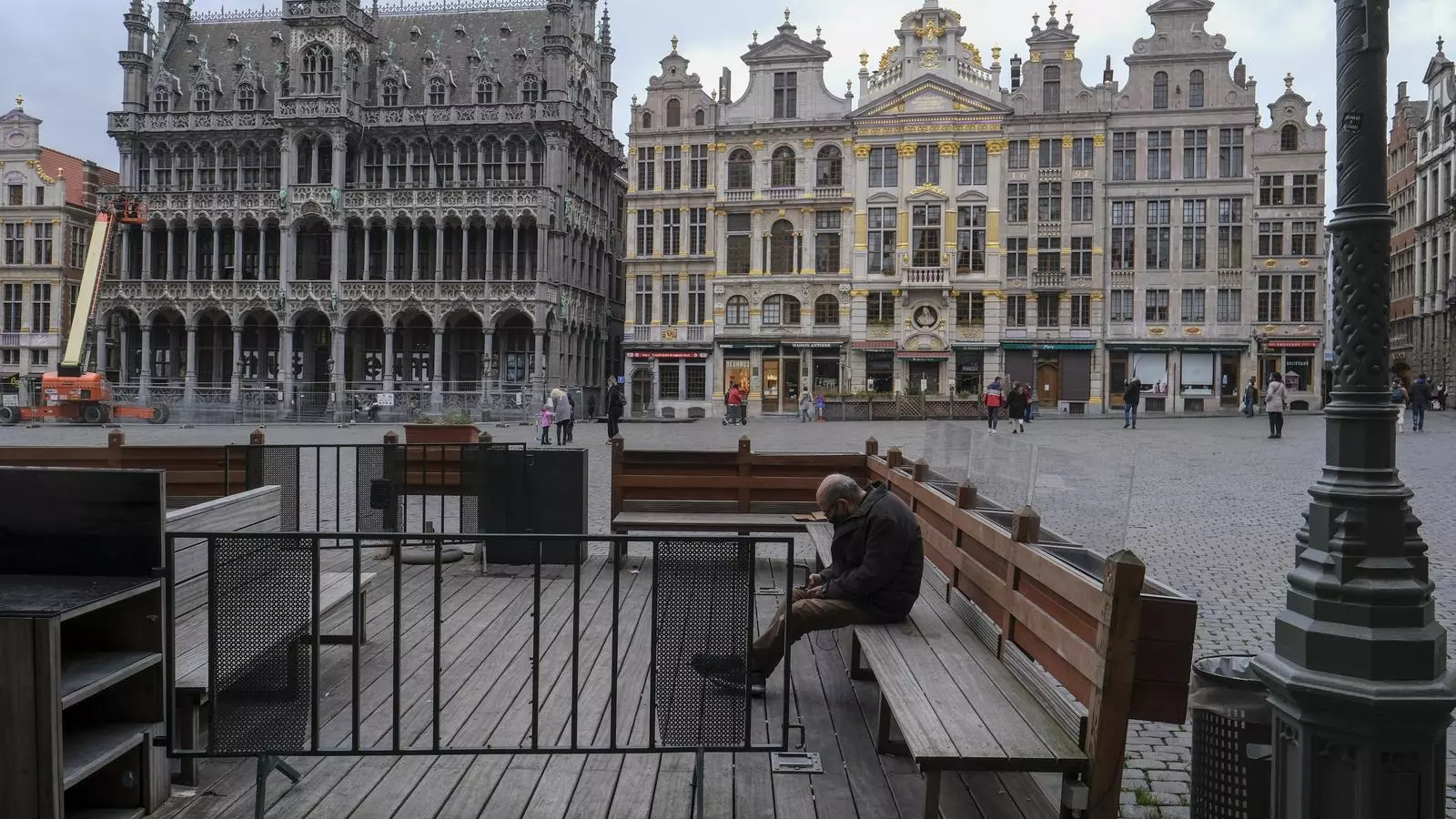 Un home resta assegut en una terrassa tancada a la Grand Place de Brussel·les, davant del tancament previst, a causa de la situació del covid-19, a Brussel·les