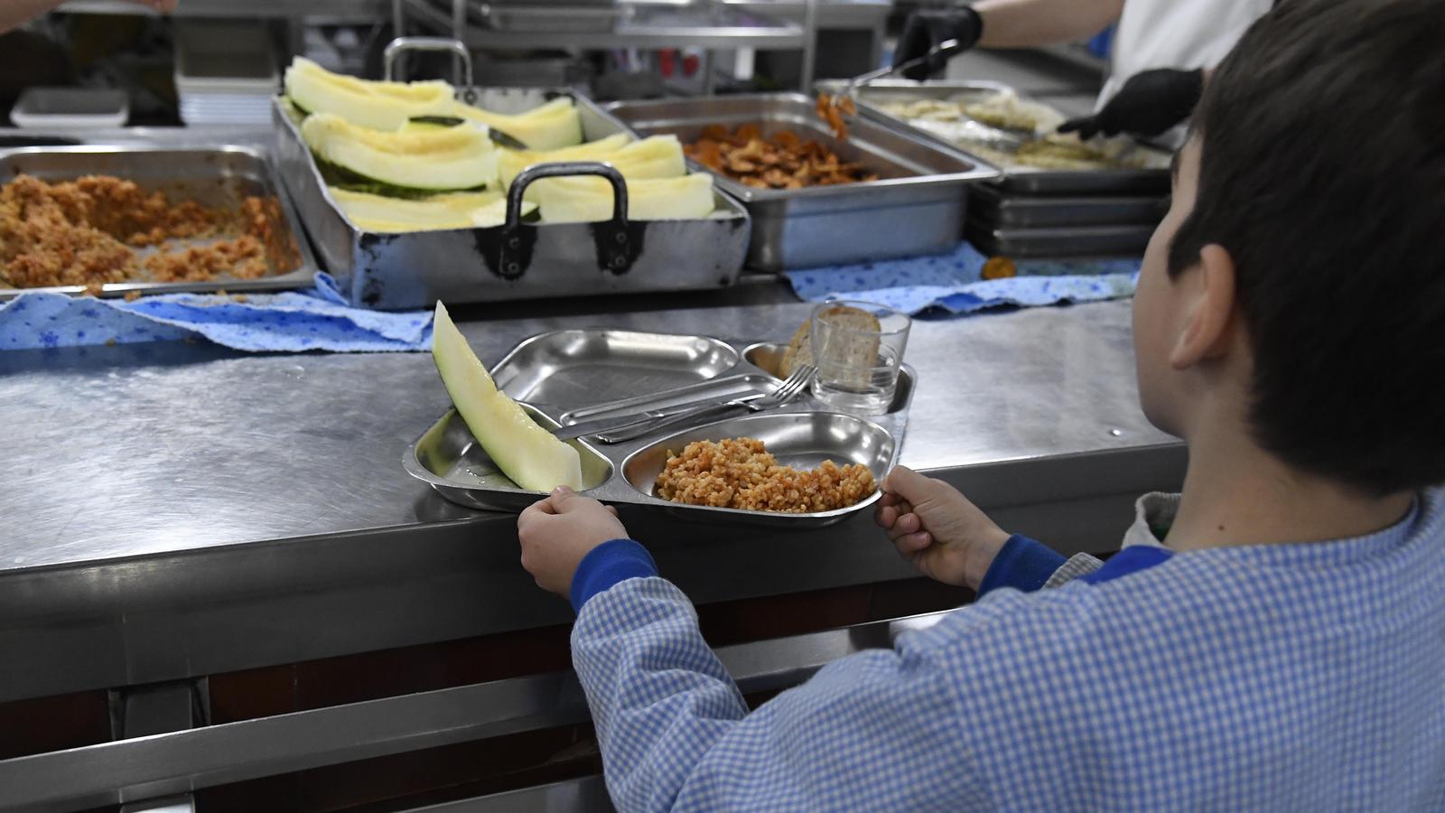 A child collects food in a school in Lleida city.