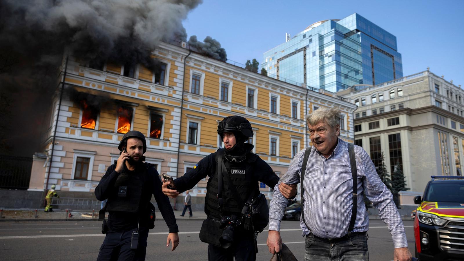 La policía se lleva a un hombre que ha escapado de un edificio bombardeado por un dron ruso en Kiev.