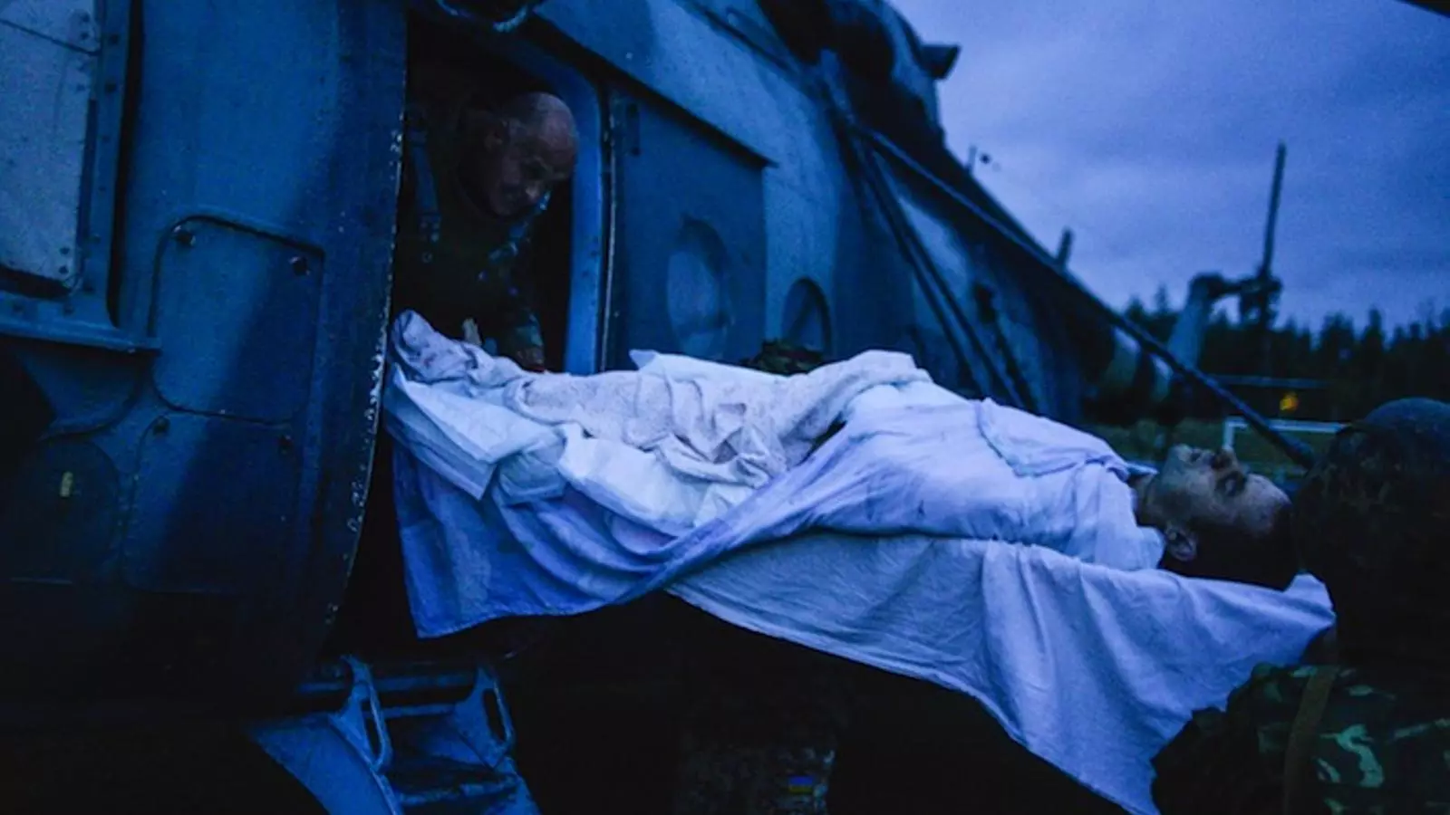 Soldats ucraïnesos baixen un dels refugiats ferits en un suposat atac dels pro-russos. ALEKSEY CHERNYSHEV / AFP