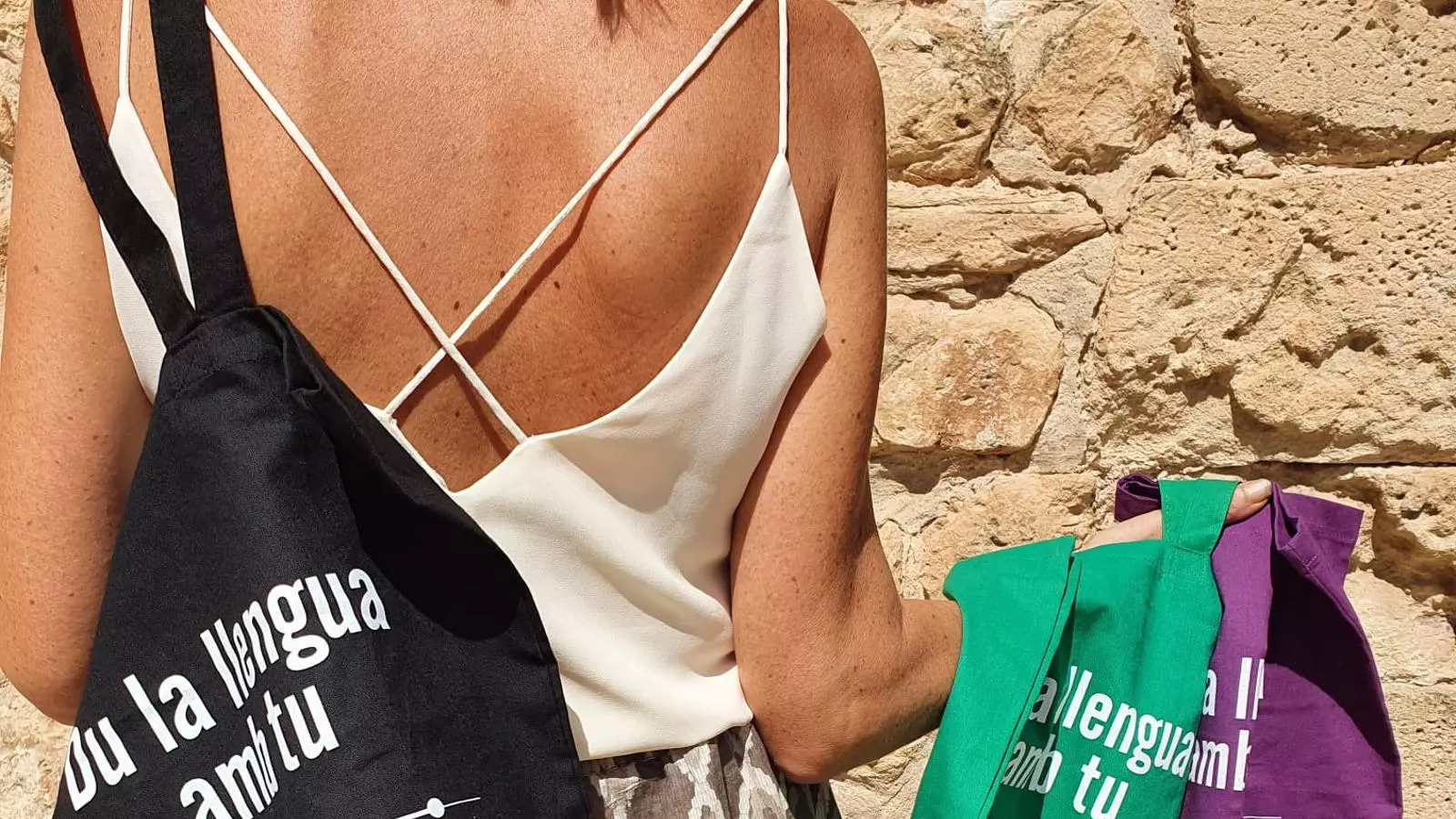 Imatge de les bosses amb el lema 'Du la llengua amb tu'.