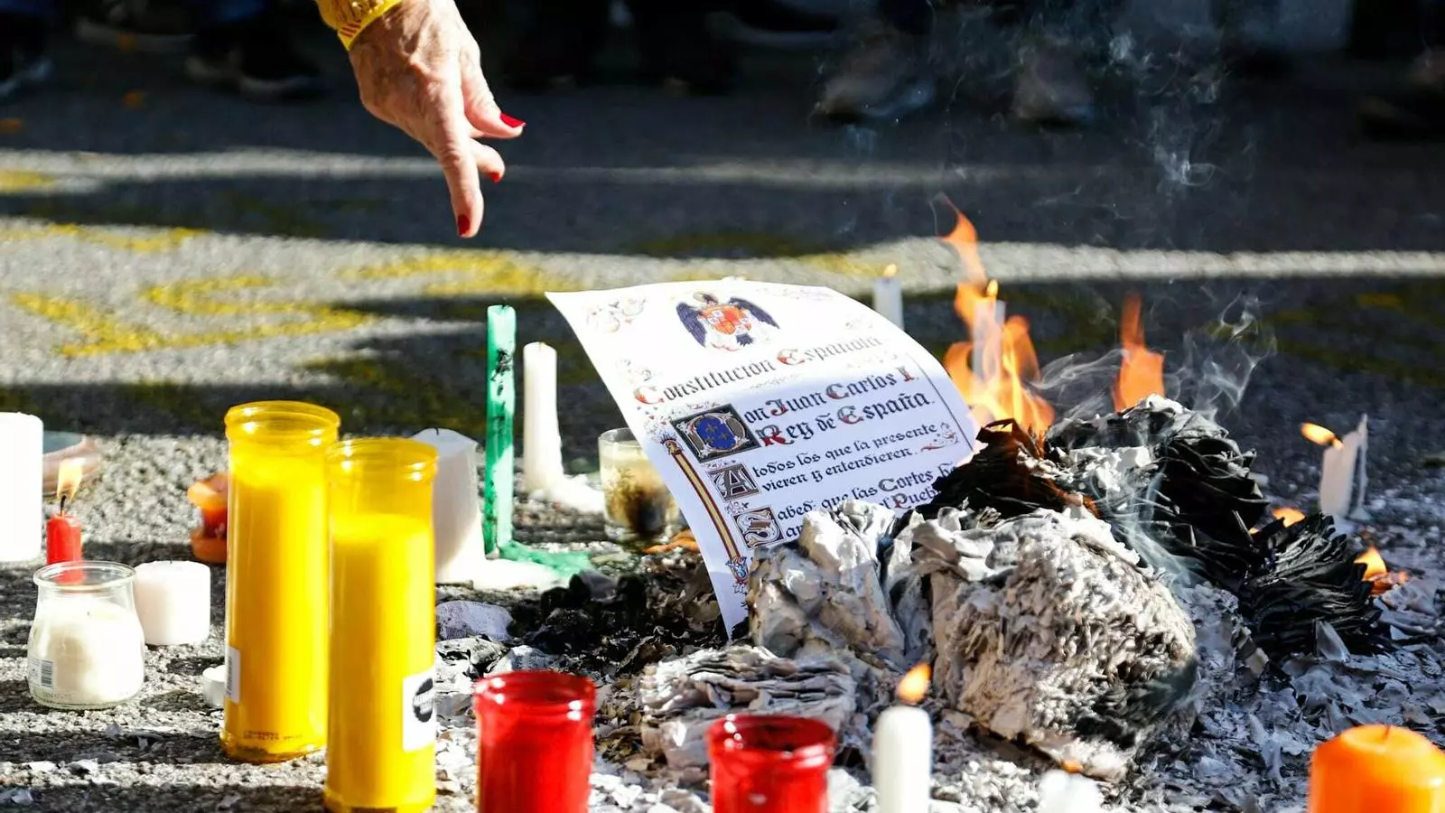 Manifestants independentistes cremen exemplars de la Constitució espanyola davant de la delegació del govern a Catalunya