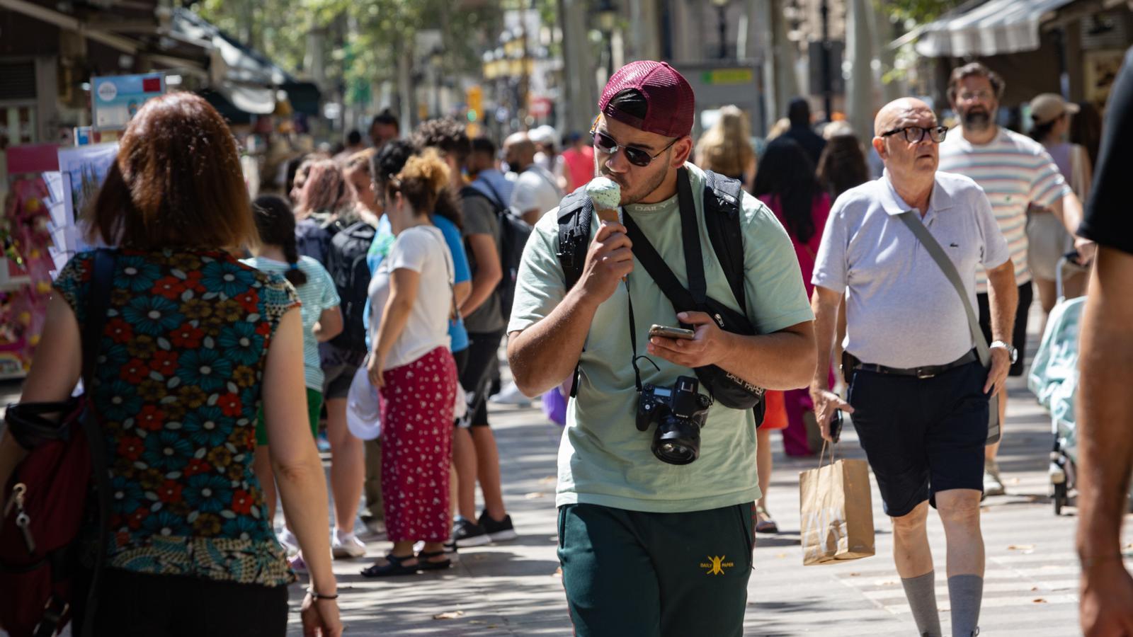 A tourist eating ice cream on the Ramblas in Barcelona.
