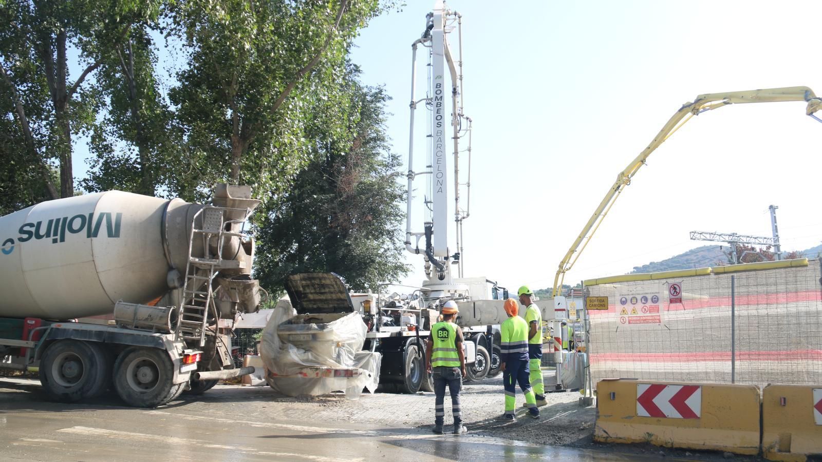 Operarios en la zona del derrumbe inyectando hormigón en el socavón.
