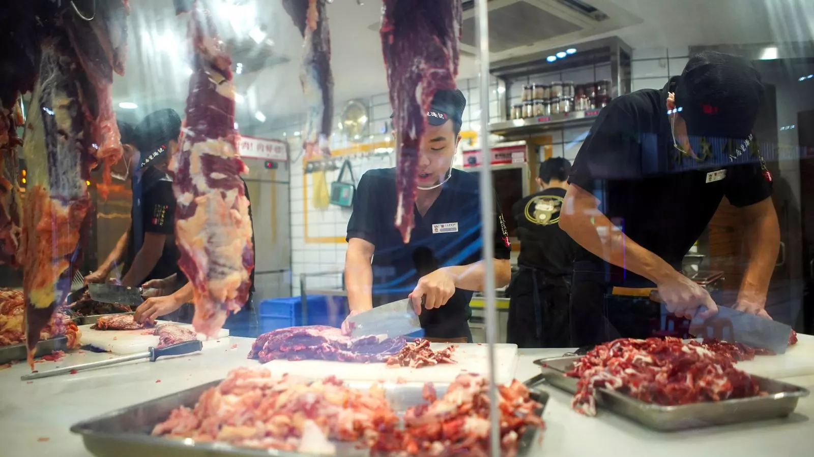 Cuiners preparant menús en un parada d'un mercat de Shezhan, en una imatge d'arxiu