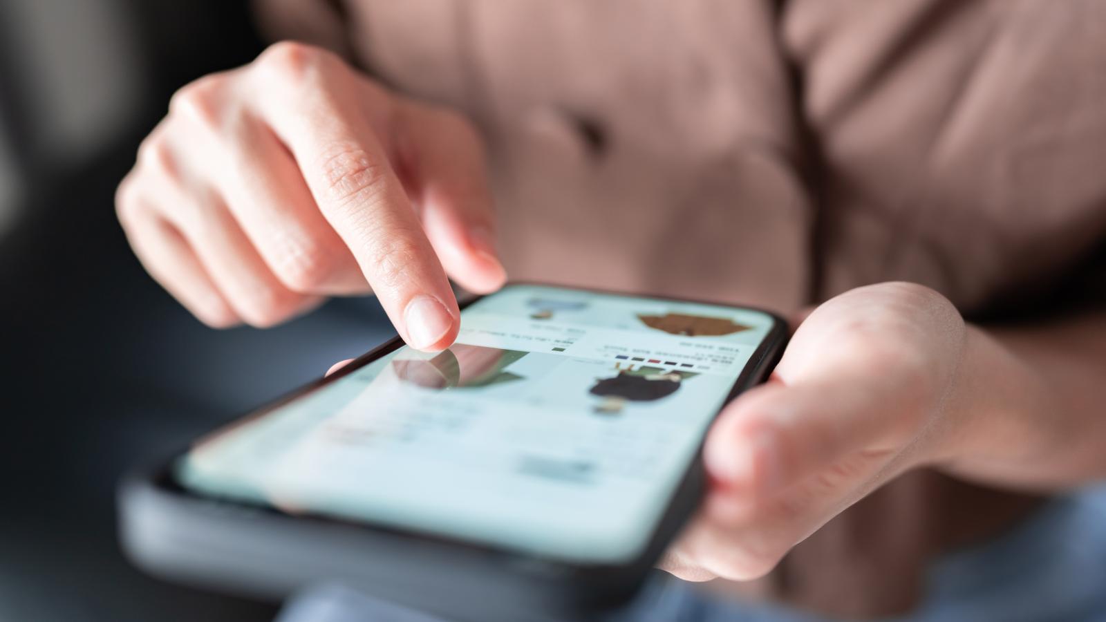A woman shopping for clothes from her phone.