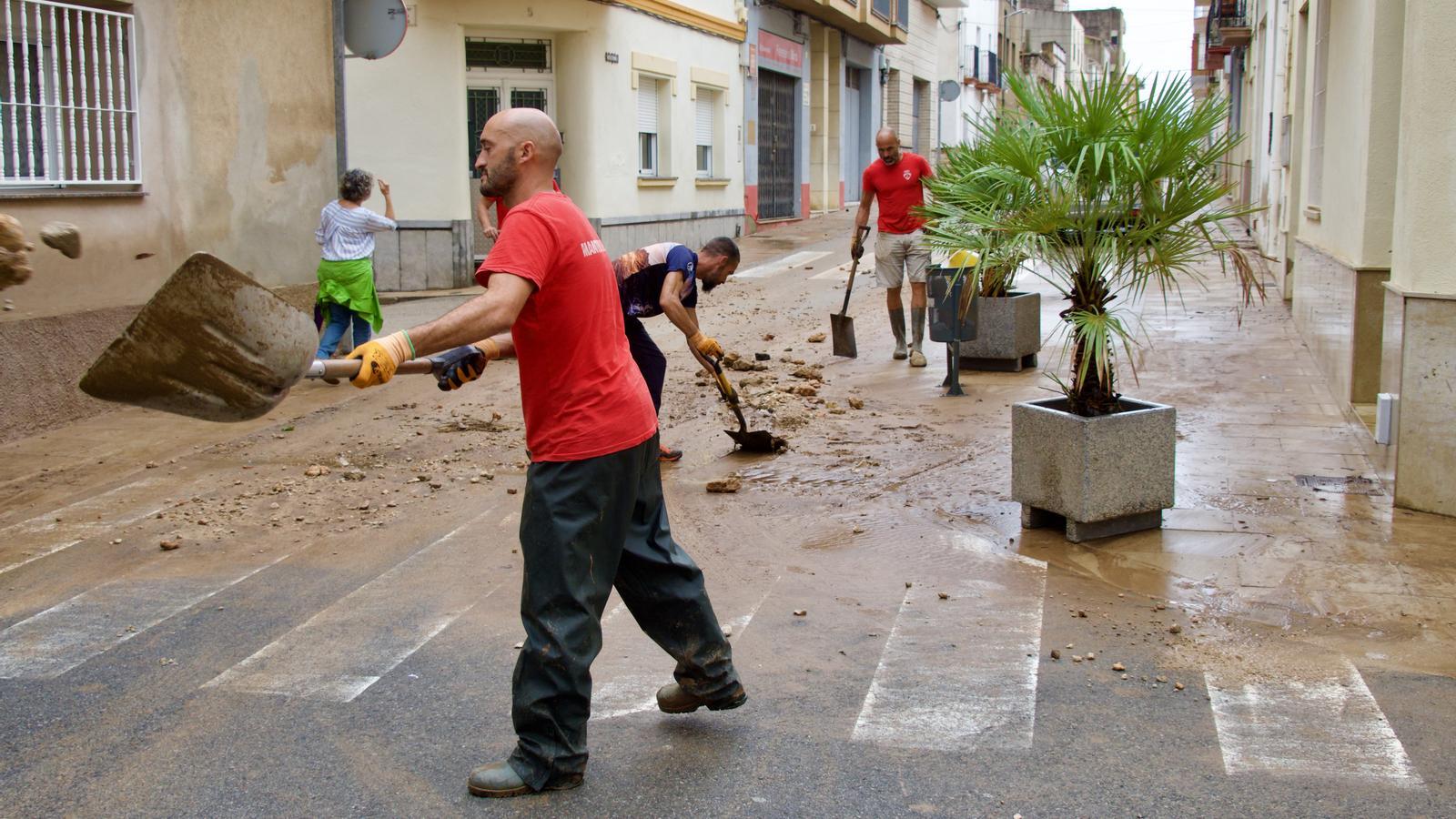 Neighbors removing the mud from the downpours in the Ebro.