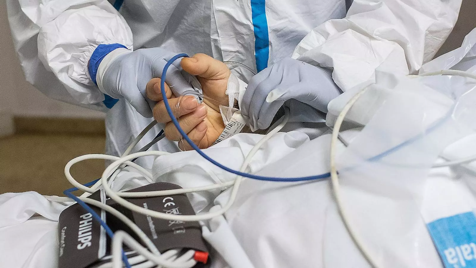 Un treballador de l’Hospital de Bellvitge donant la mà a un pacient de covid-19.