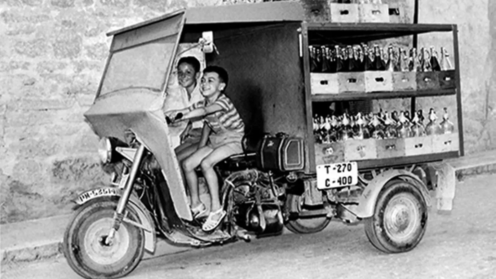Els inicis de les Begudes Puig amb infants pujant al carro de les begudes.