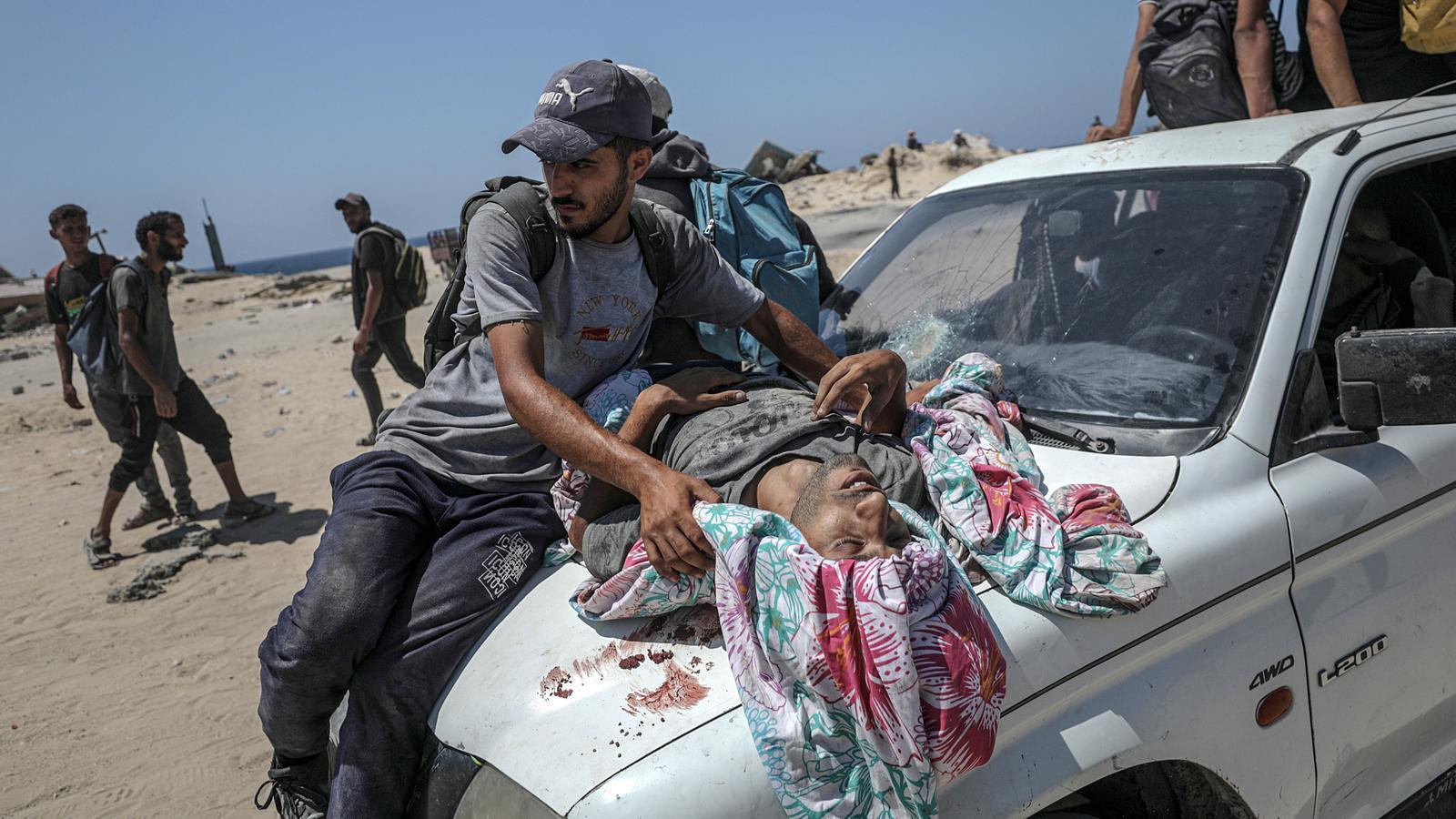A man was carried on the hood of a car after being seriously wounded by gunfire at a food distribution point near Zikim, in the northern Gaza Strip, on July 20, 2025.