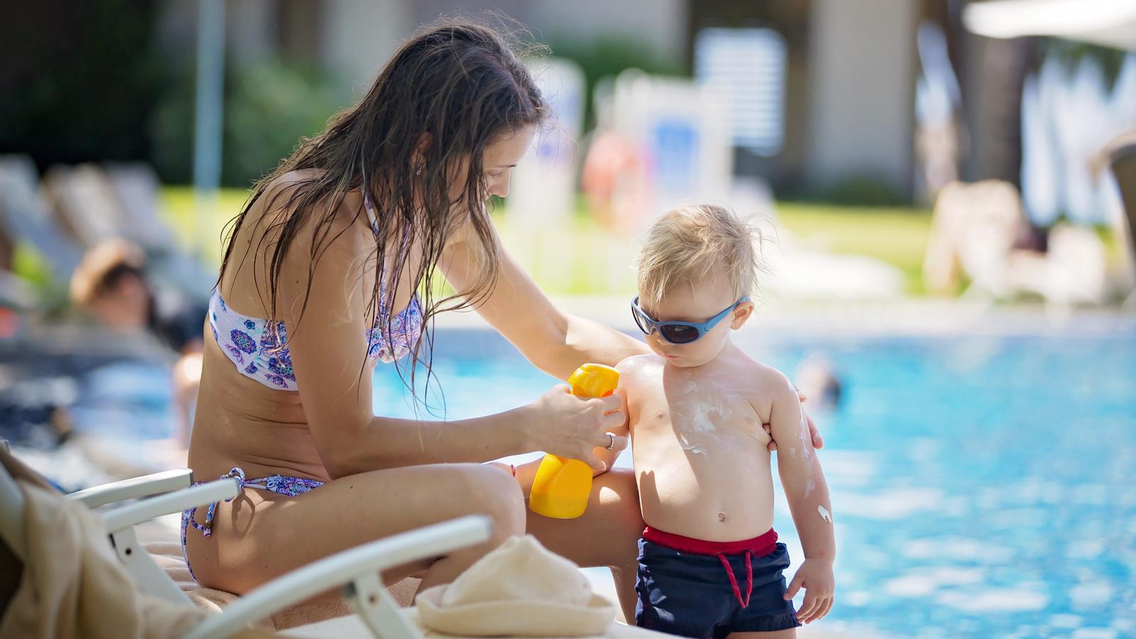 A woman applies sunscreen to a toddler in a file photo.