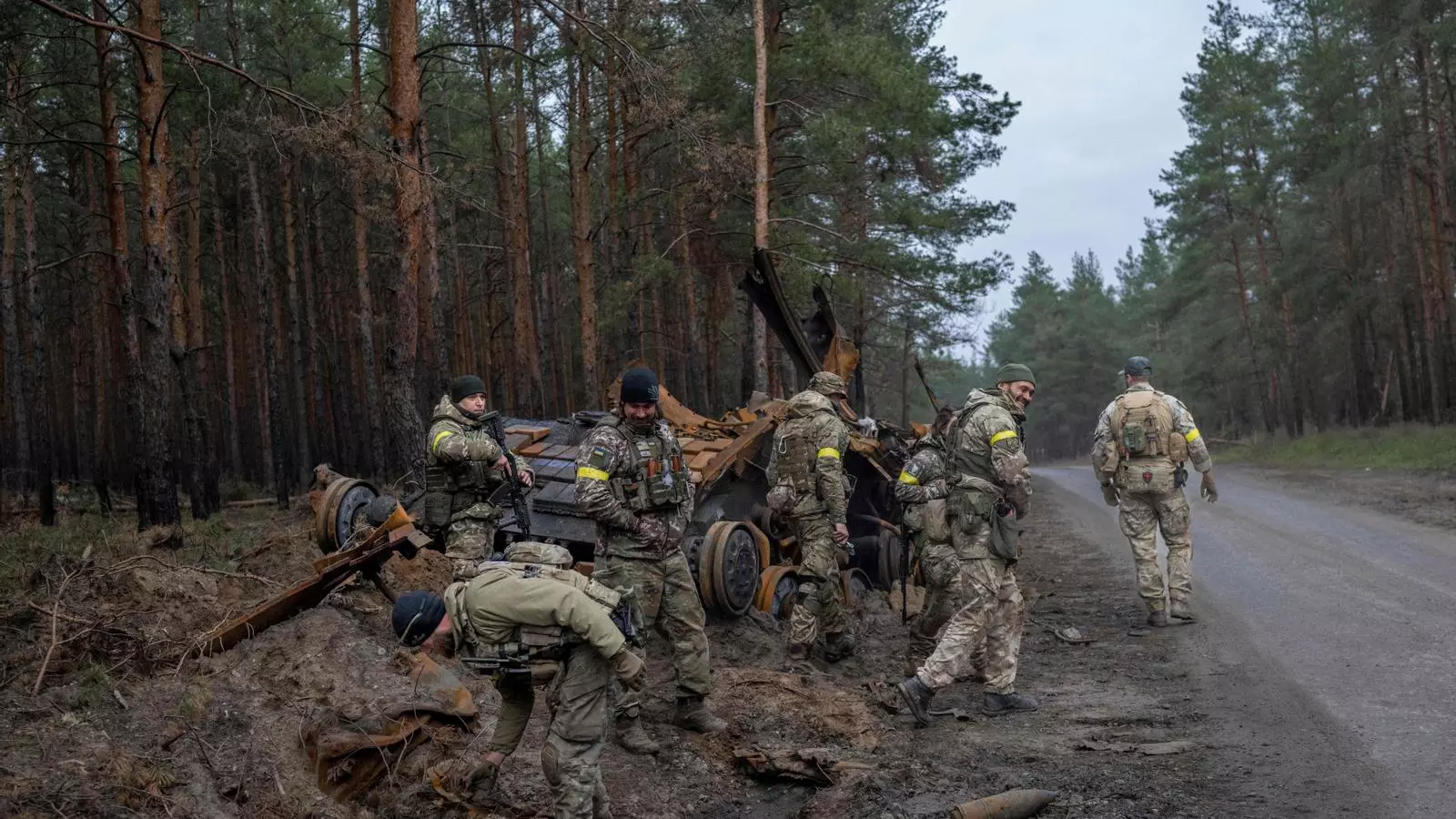 Soldats ucraïnesos i combatents voluntaris inspeccionen un tanc rus destruït en un lloc no identificat , a l'est d'Ucraïna el 10 de novembre de 2022
