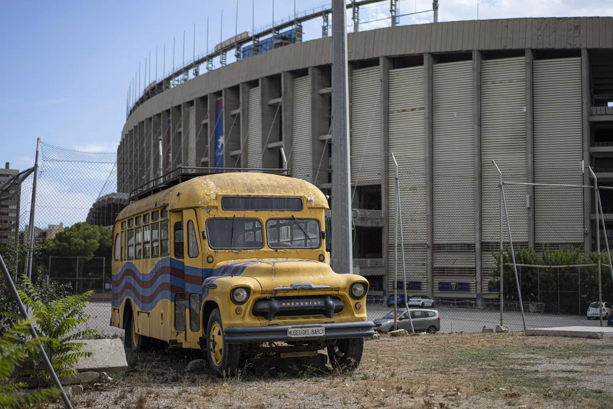 Autobus groc en mal estat davant de la Masia del Barça, al costat del Camp Nou