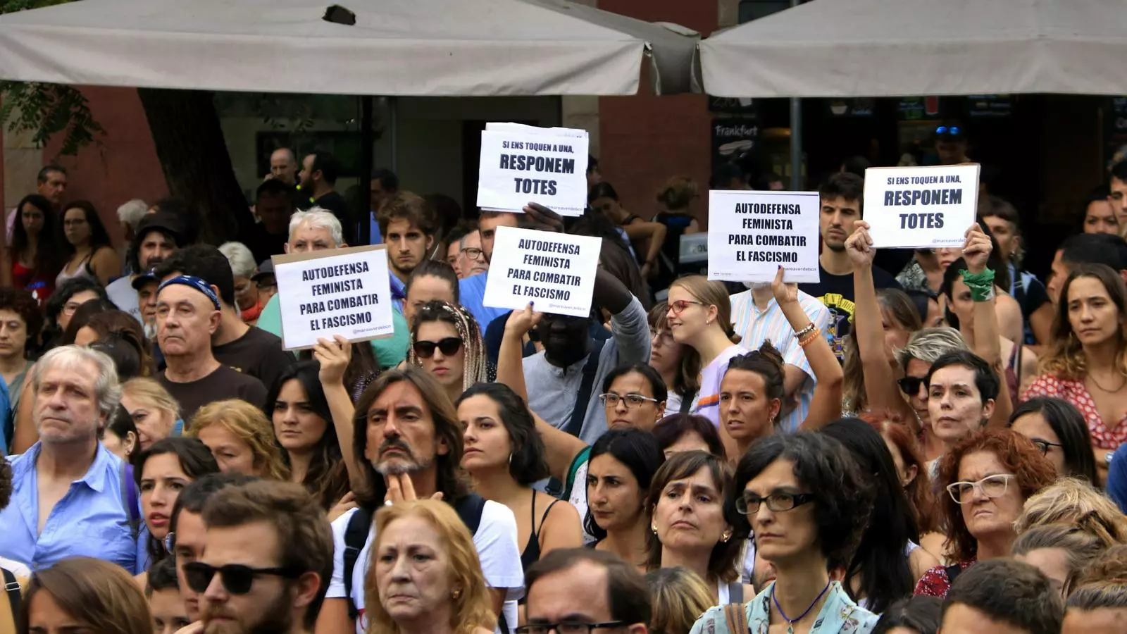 Persones amb cartells amb missatges feministes a la plaça de la Vila de Gràcia per condemnar la violació d'una noia quan tornava de les festes