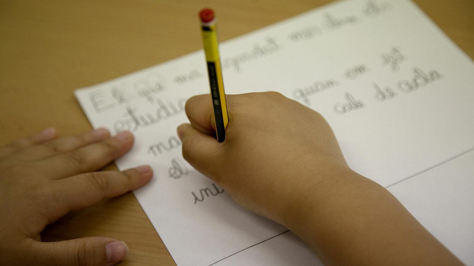 A student writing, in a file image.