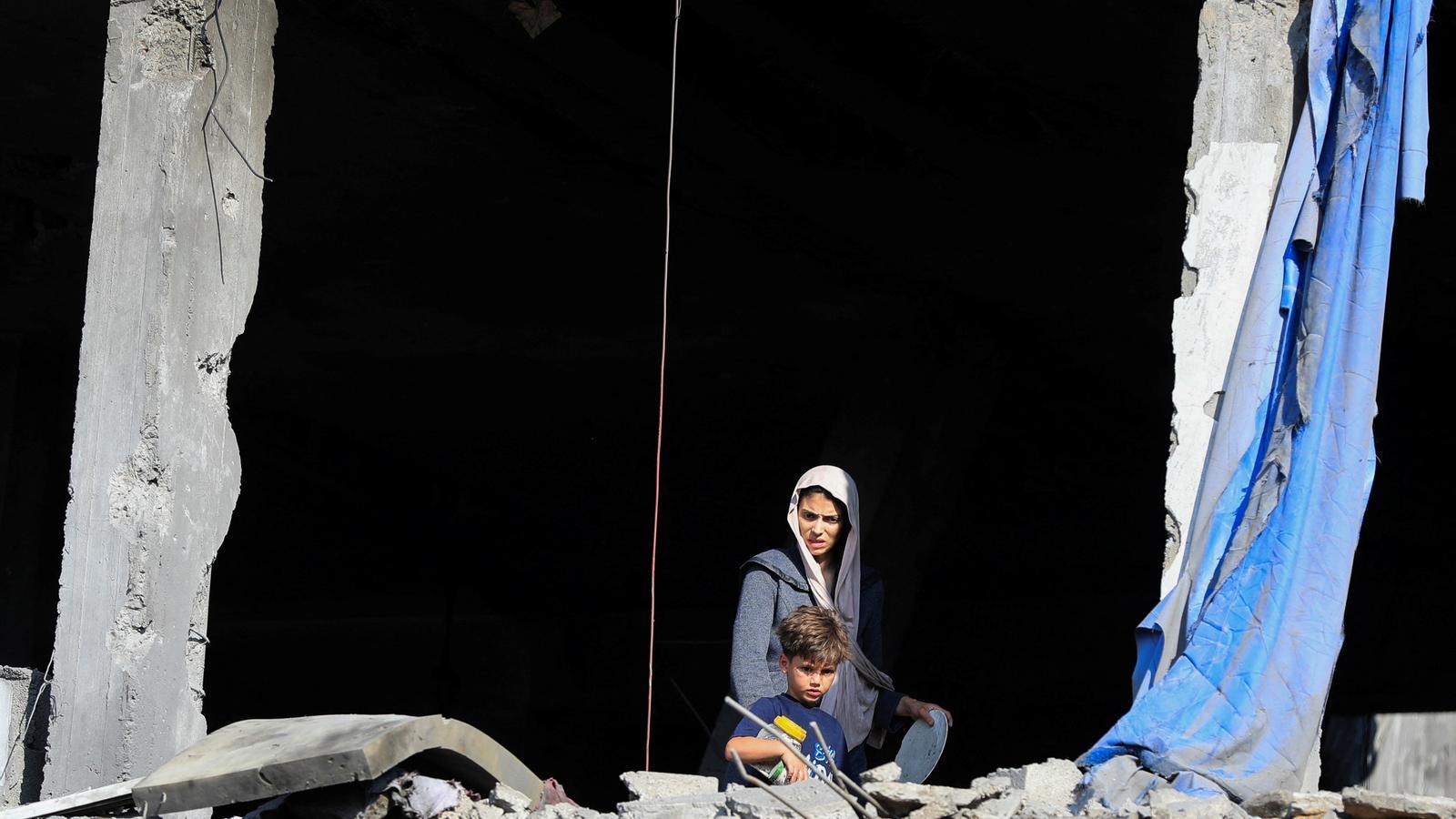 Una mujer palestina y un niño en un edificio atacado por el ejército israelí en la ciudad de Gaza, esta semana.