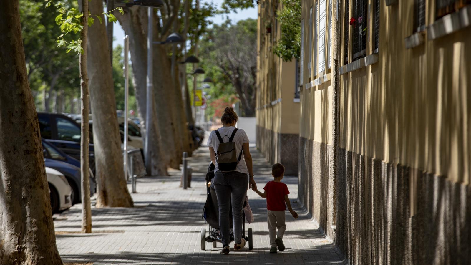 Una mujer con su hijo paseando por el barrio de Sant Cosme, en El Prat de Llobregat