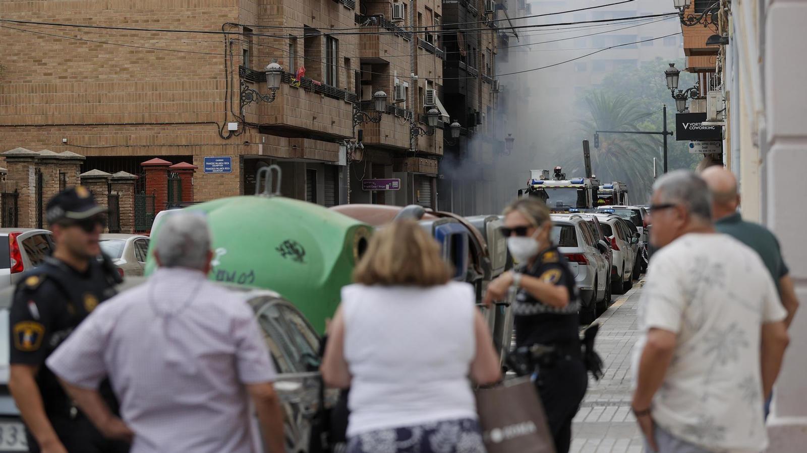 Several residents of Valencia observe the smoke generated by a fire that burned down a commercial premises.