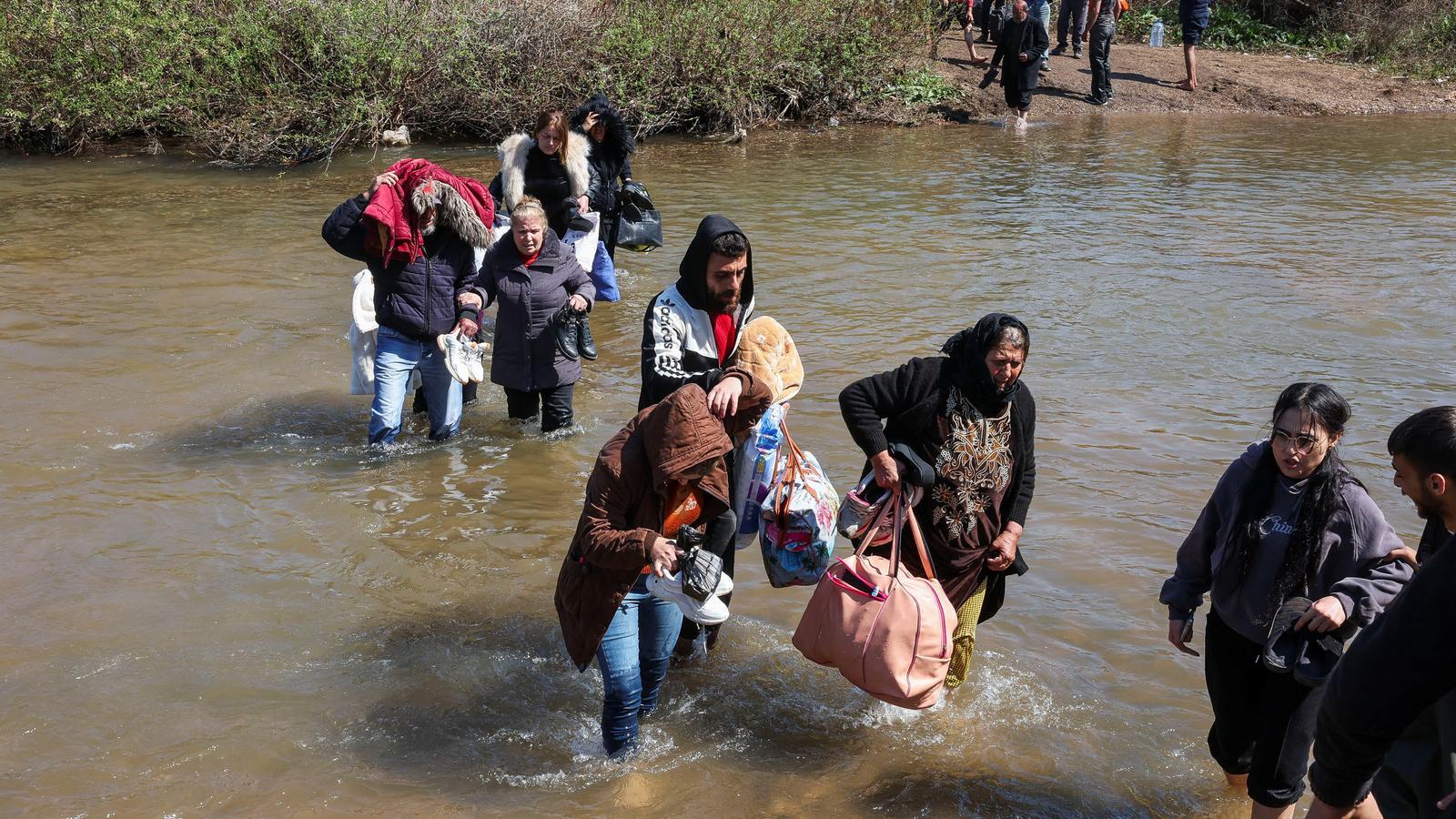 Alawite Syrians flee the violence in western Syria, crossing the Nahr El Kabir River.