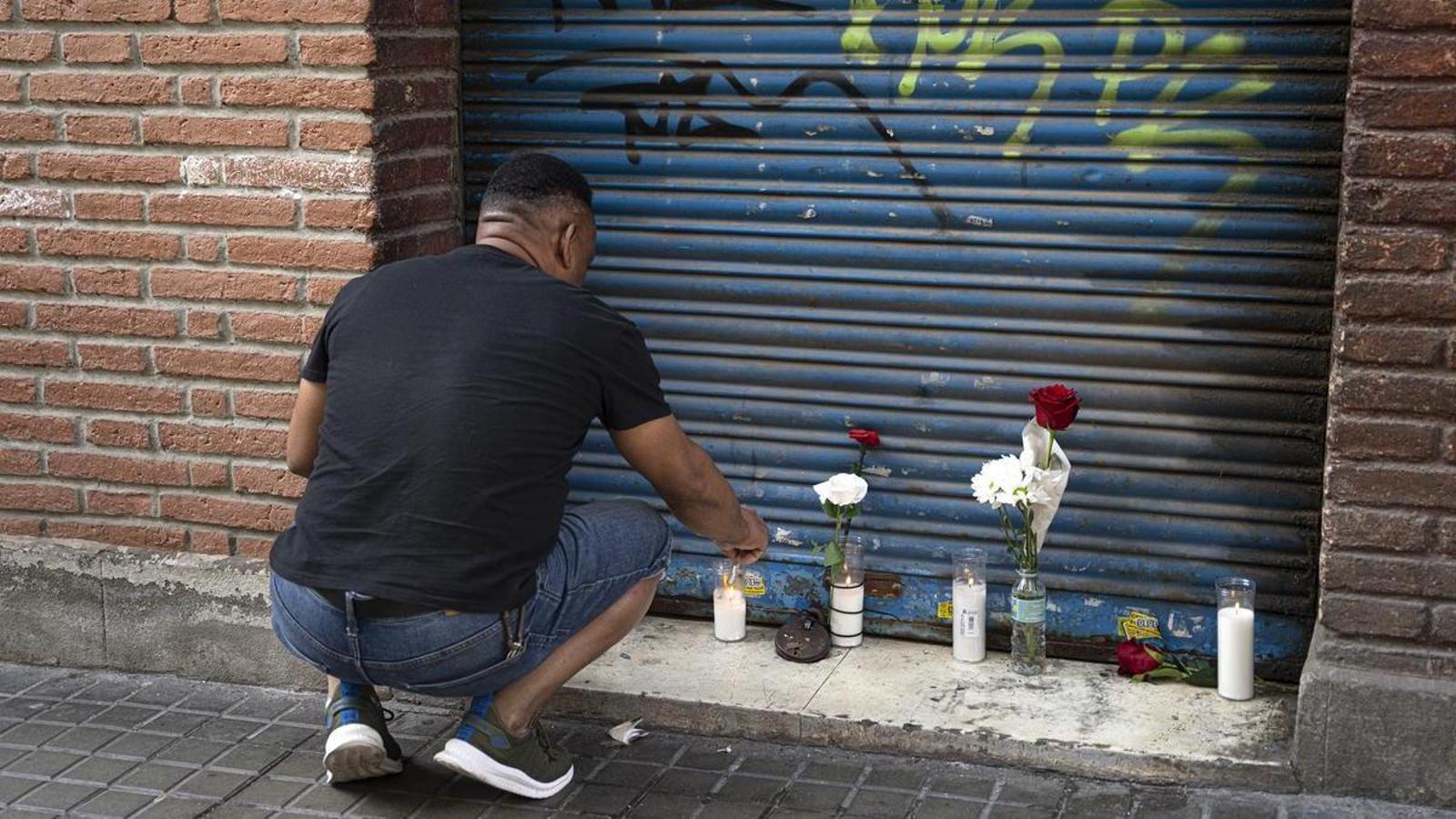 A neighbor of Javi placing a candle in his memory, at the shoe store he managed