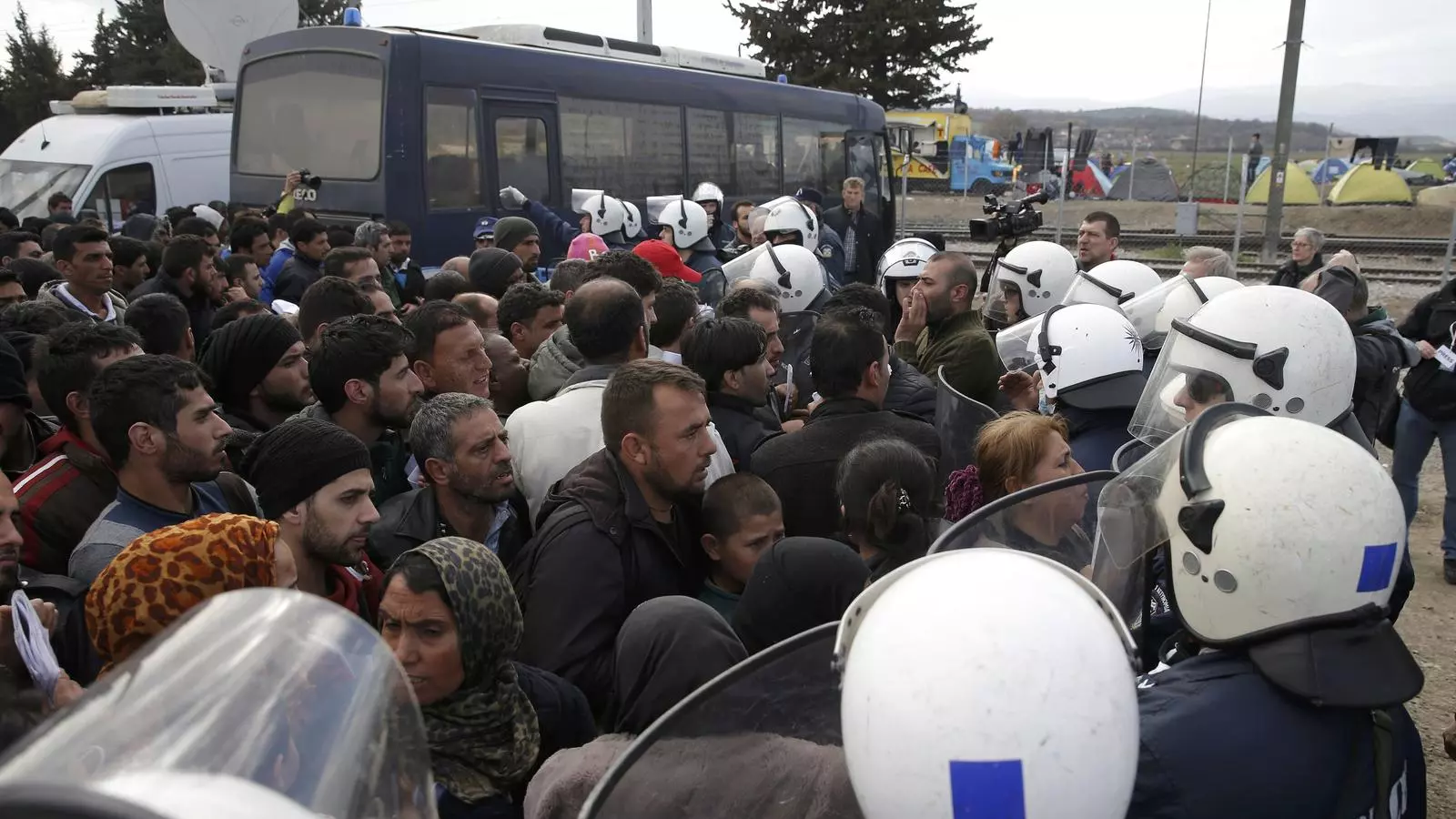 Un grup de refugiats discuteix amb la policia a la frontera entre Grècia i Macedònia