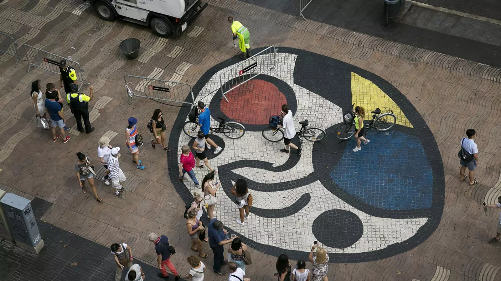 Mosaic del Pla de l'Os de Joan Miró a La Rambla de Barcelona, camí natural de qui va o ve del mar a la ciutat. Després de l'atemptat de Barcelona, l'obra d'art va ser coberta de flors i altres mostres de suport per les víctimes i els seus familiars. Ara, els equips de neteja redibuixen les pinzellades de l'artista català.