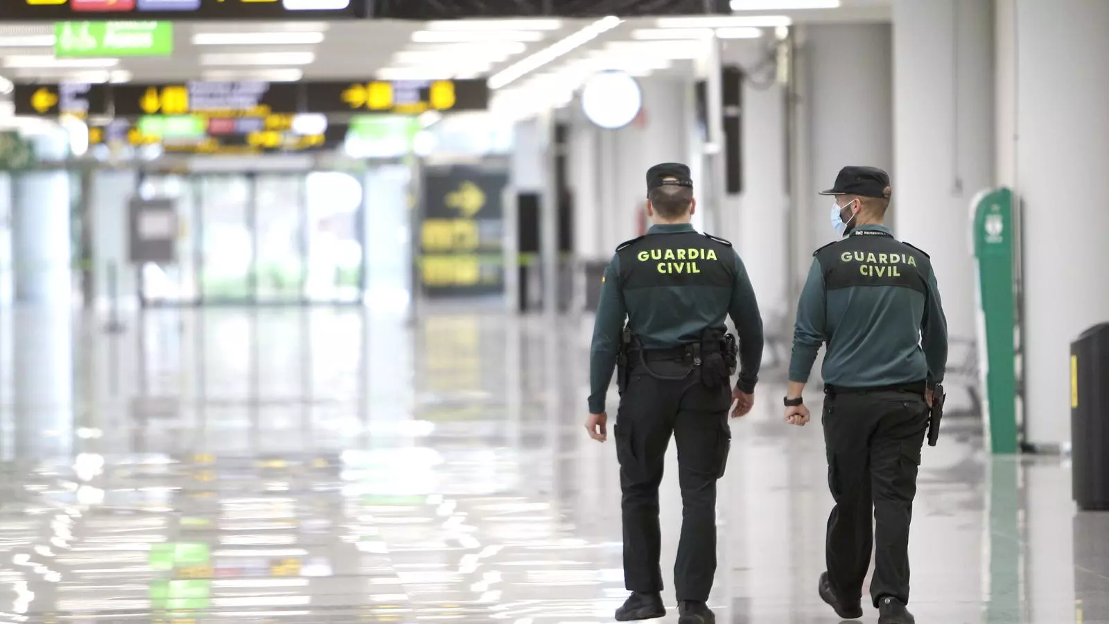 Dos agents de la Guàrdia Civil caminen per la terminal d'arribades de Son Sant Joan.