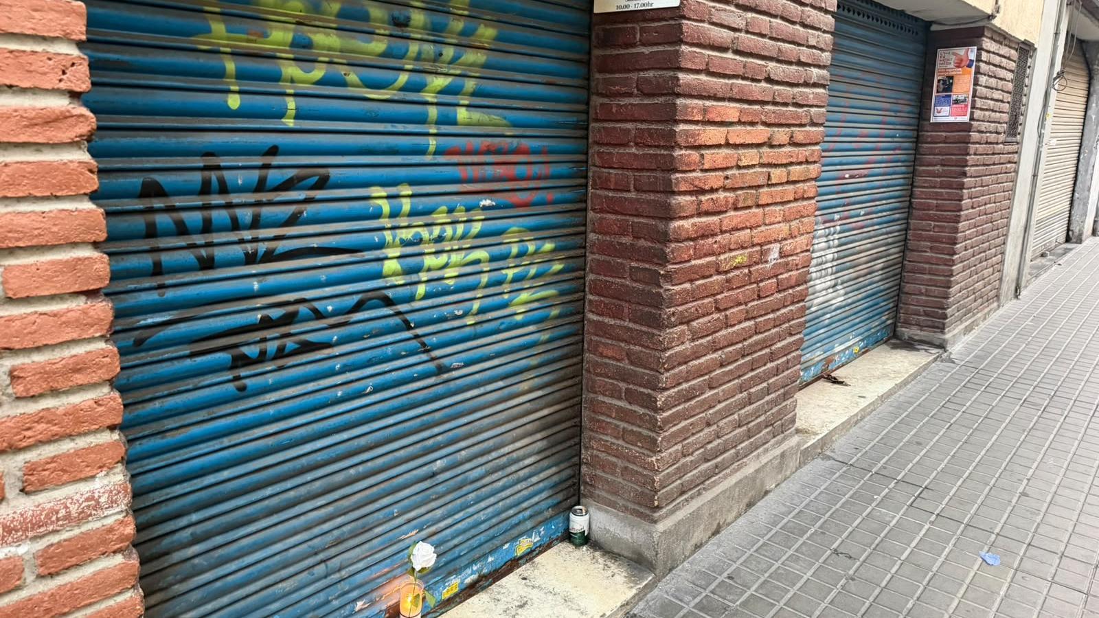 A candle remembers Javi in front of his shoe store.
