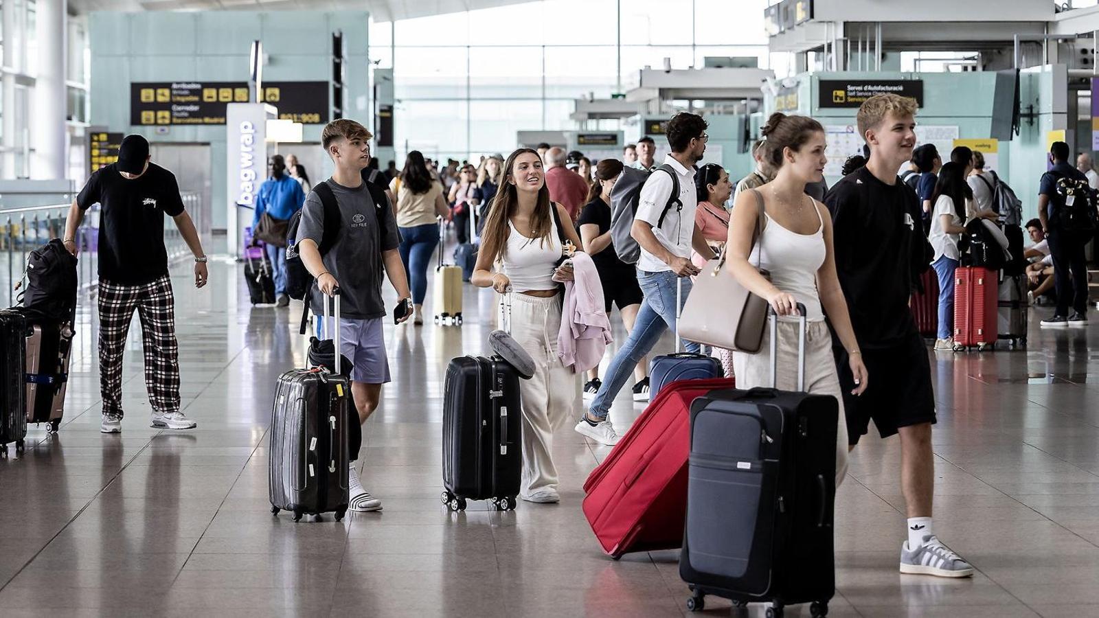 Passengers with hand luggage at El Prat Airport. PERE VIRGILI
