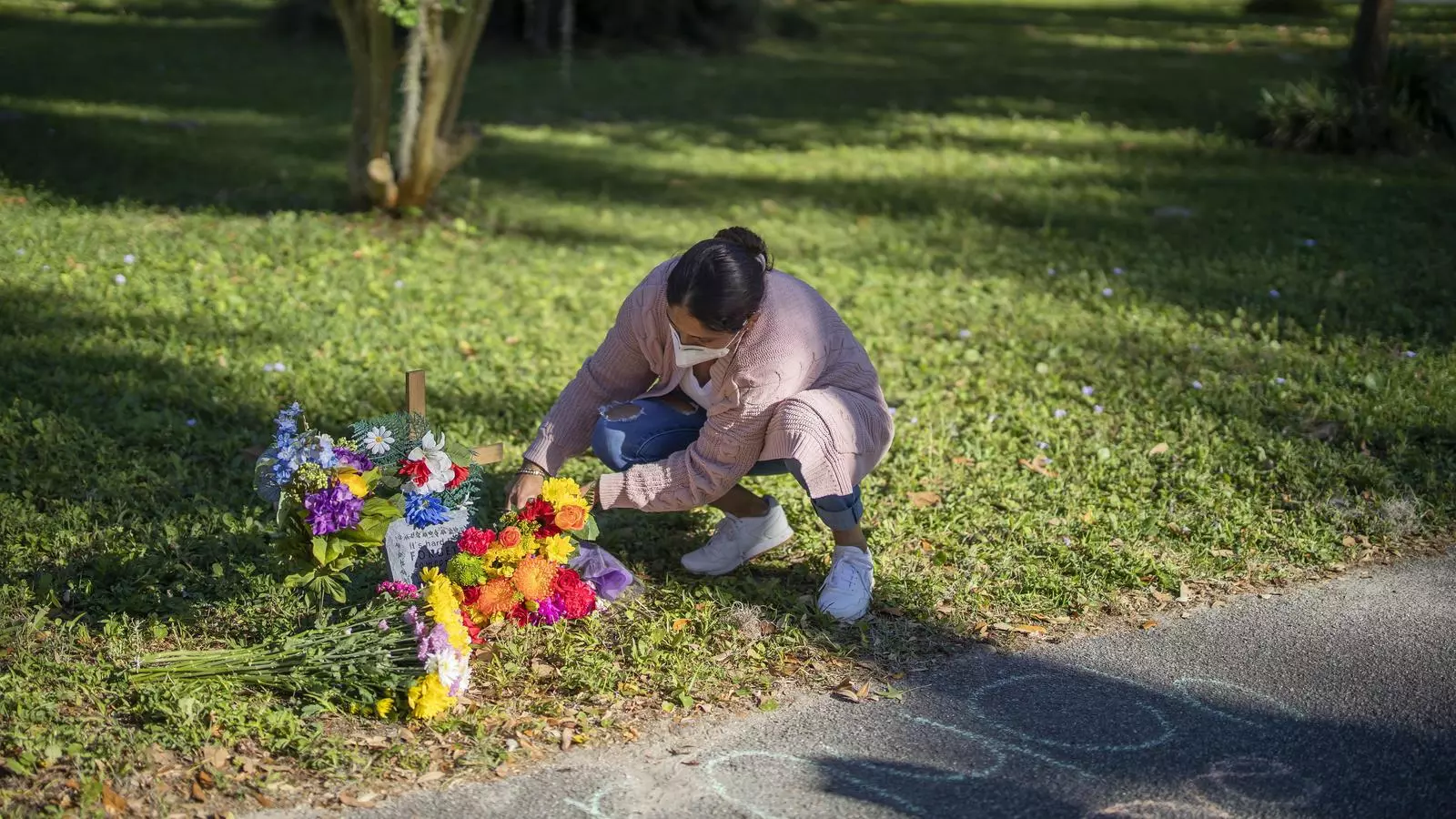 Una dona col·locant flors al memorial alçat al carrer on uns supremacistes van assassinar Ahmaud Arbery, en un barri residencial de Geòrgia