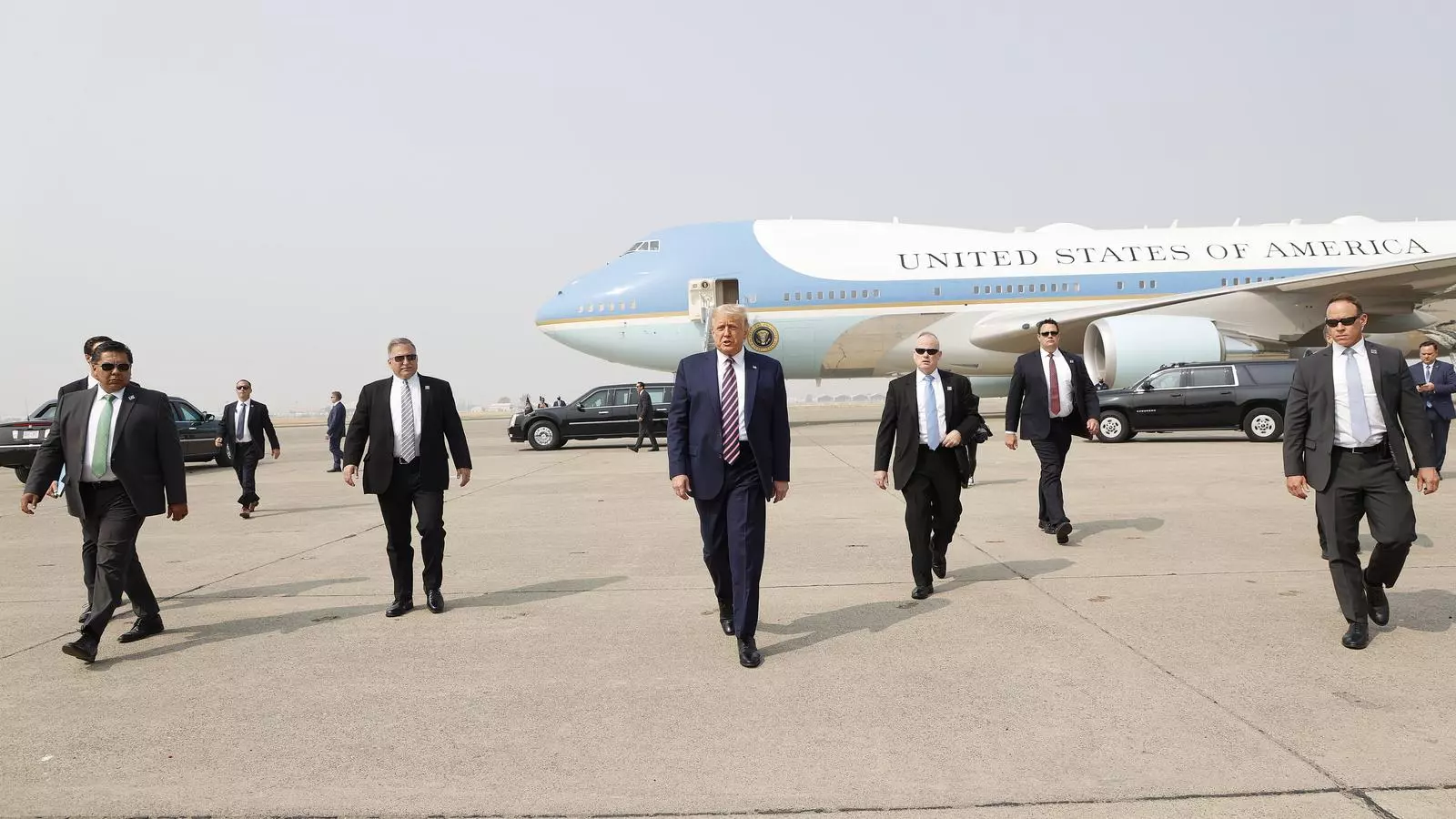 El president Donald J. Trump envoltat d'agens del seu servei secret després d'arribar a l'Air Force One a l'aeroport de Sacramento McClellan, Califòrnia
