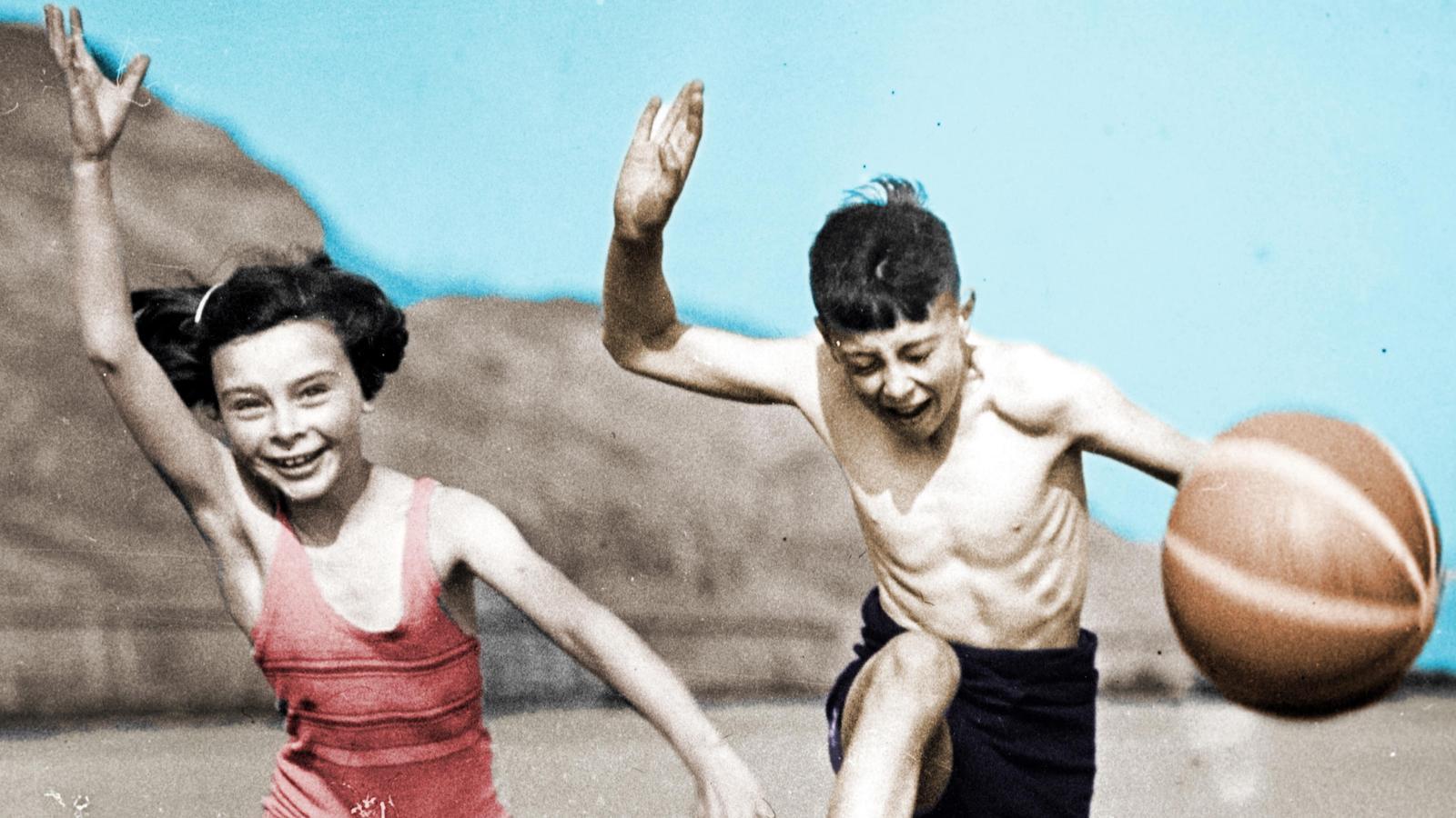 Un nen i una nena jugant a la platja
