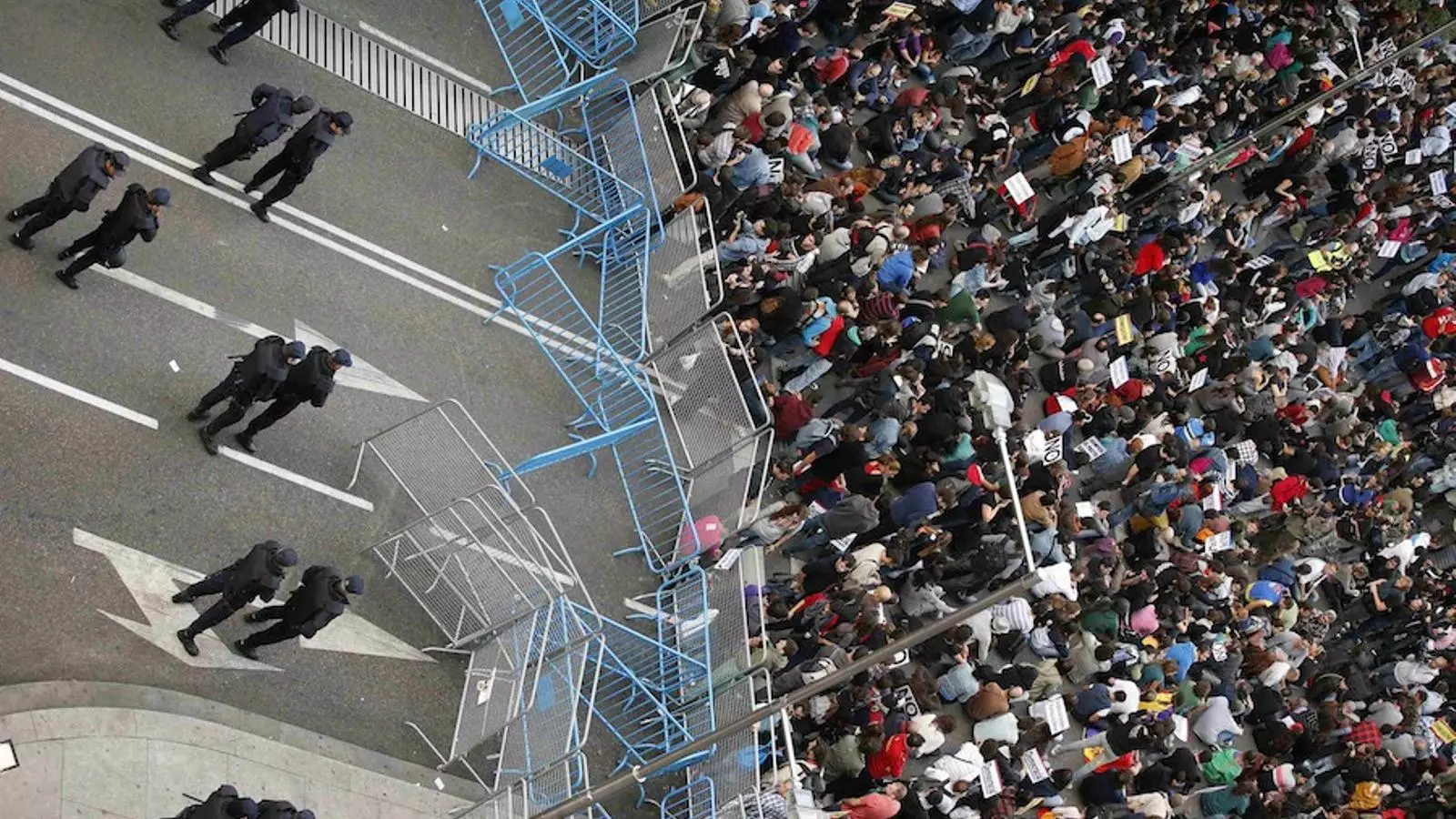 Manifestants asseguts sota la vigilància dels antidisturbis als voltants del Congrés, aquest dimecres al vespre / SERGIO PEREZ / REUTERS