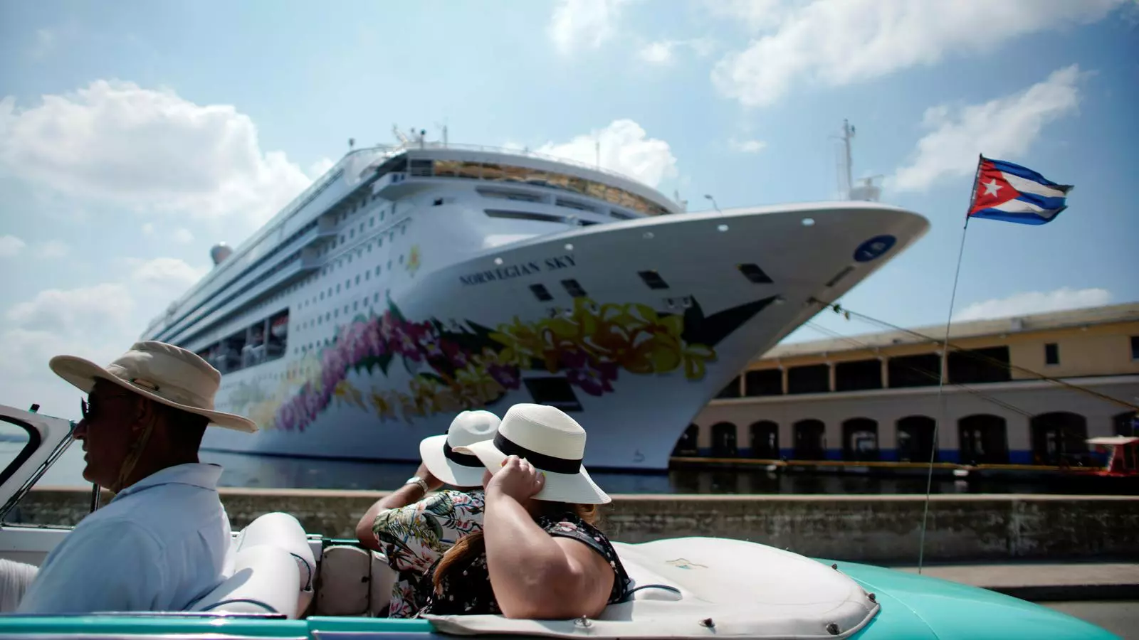Dues turistes passant davant d'un dels creuers atracats al port de l'Havana, en una imatge d'arxiu