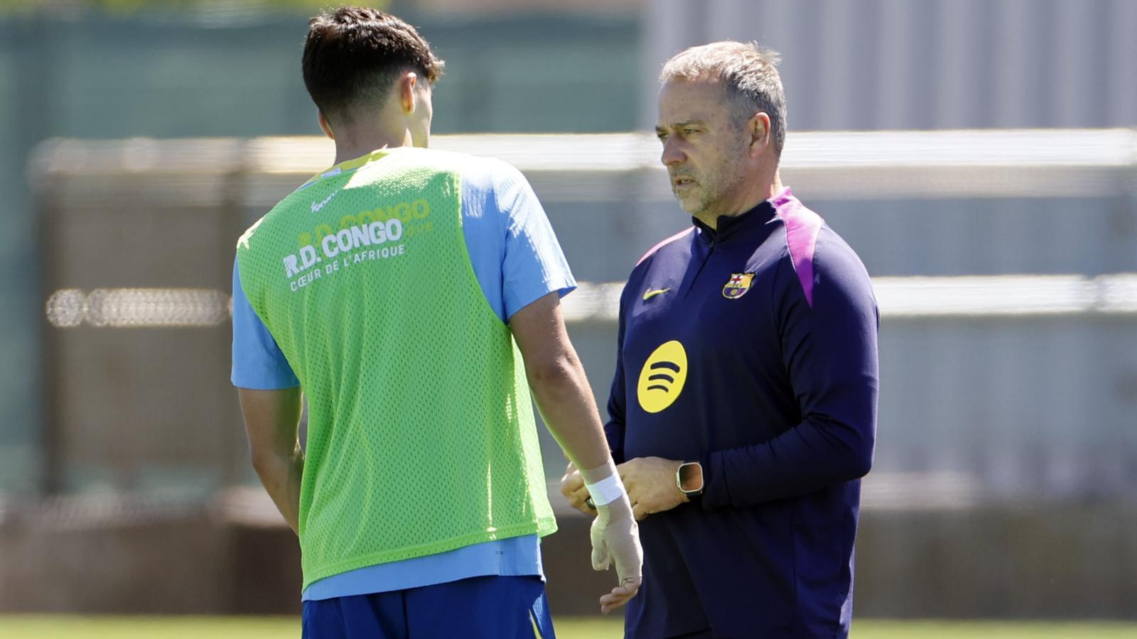Pau Cubarsí, with the sponsorship of Congo on his back, talking with Hansi Flick in a Barça training session.