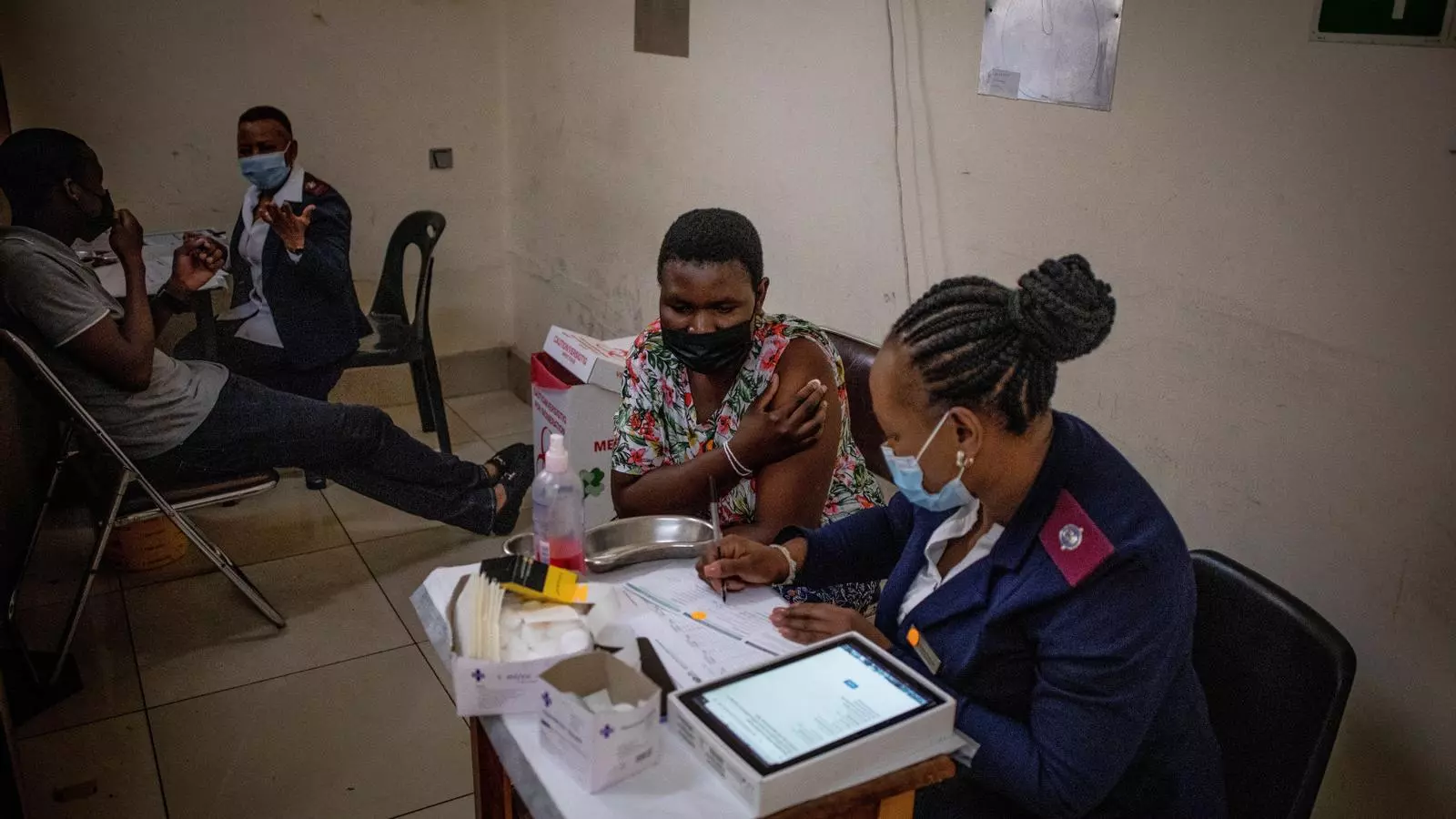 Una dona s'asseu amb una infermera després d'haver rebut la vacuna contra la COVID-19, en una clínica administrada pel govern a Hillbrow, Johannesburg
