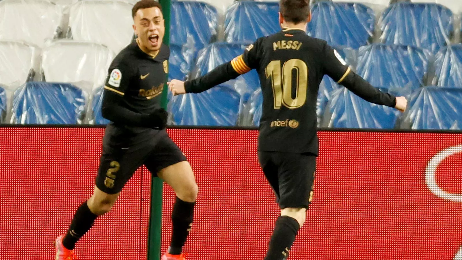 Dest, davant de Messi, celebrant un dels seus dos gols contra la Reial Societat