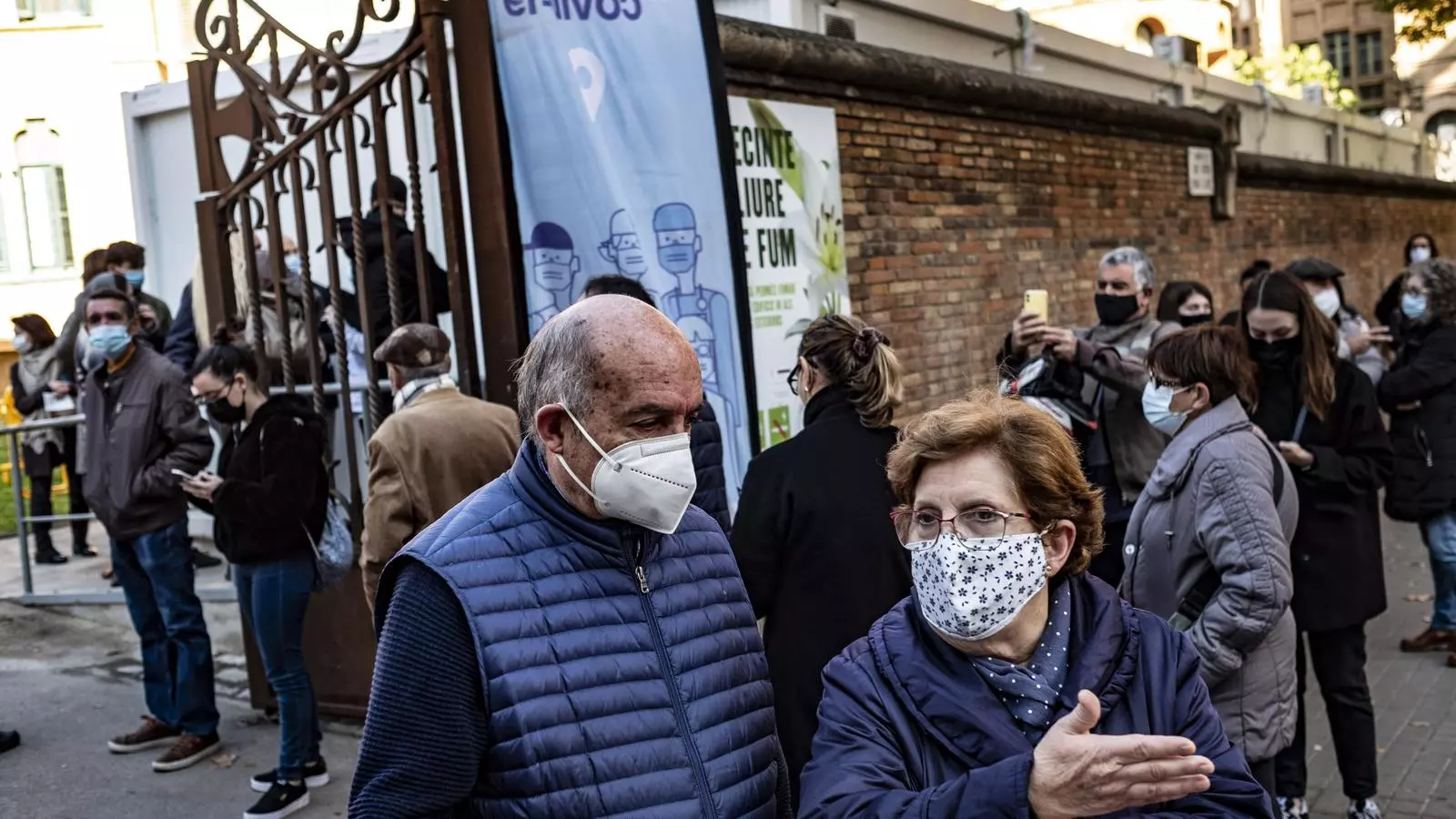 Dos personas saliente del punto de vacunación del Hospital Santo Pau, donde se ponen terceras dosis a los mayores de 60 años.