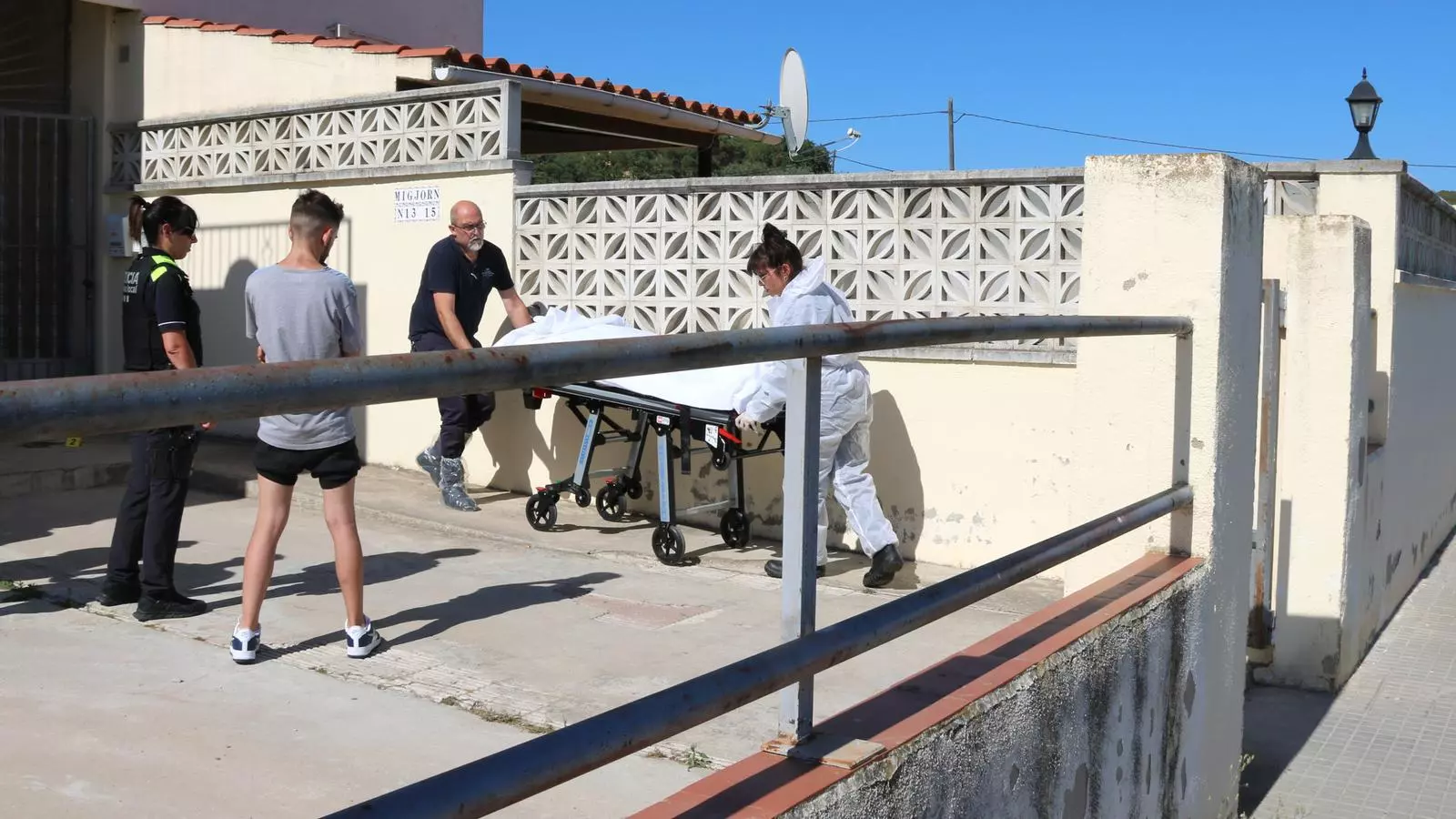 Treballadors de la funerària s'emporten el cos de la víctima